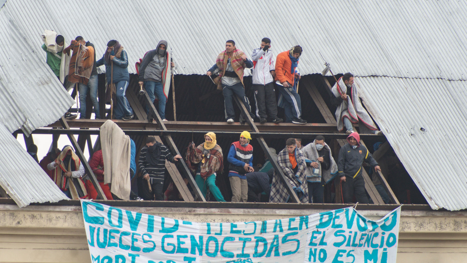 Los presos se tapan con mantas para amortiguar el impacto de las balas de goma. 