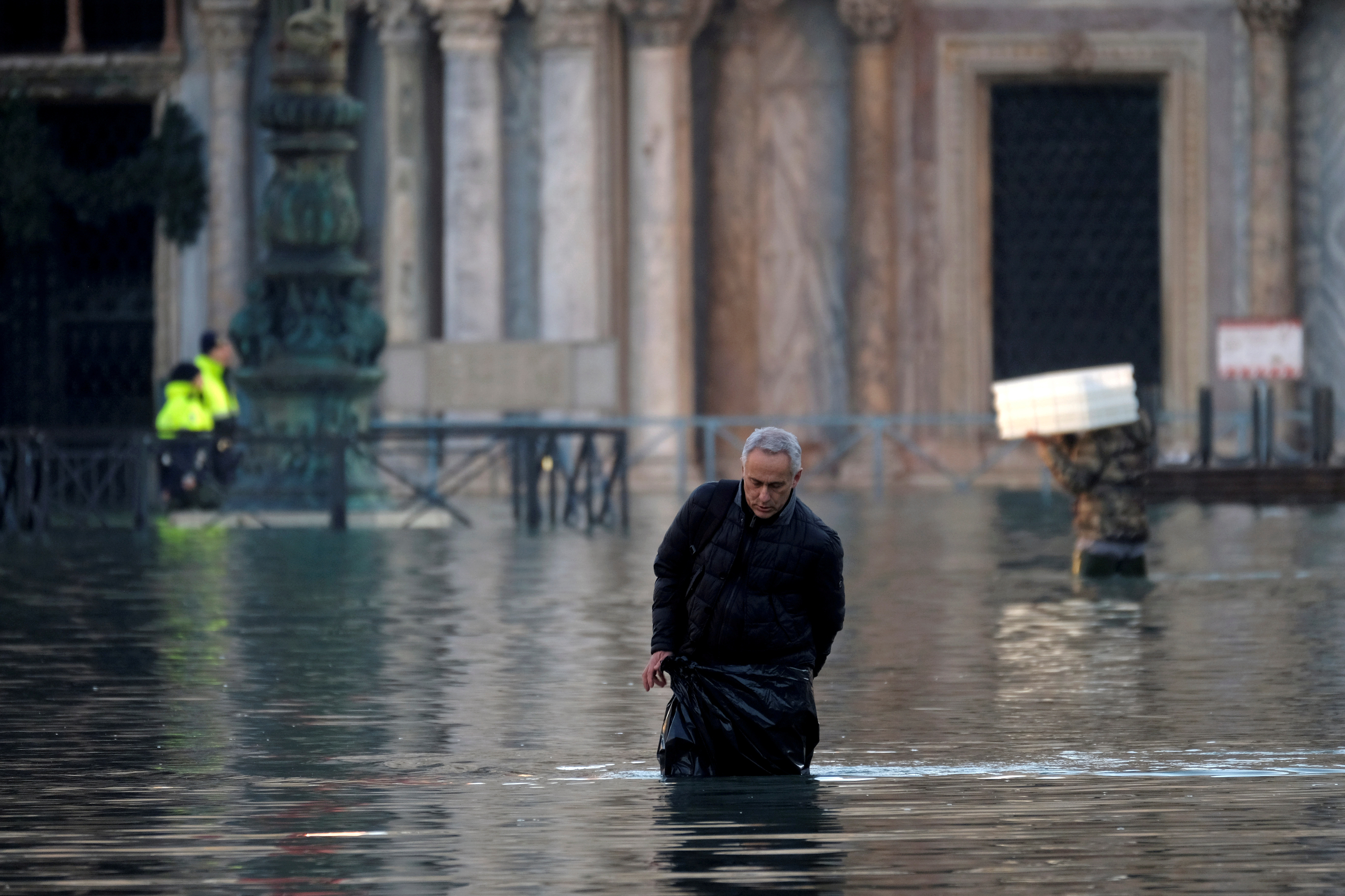 Un hombre camina a través de una calle inundada hacia la Plaza de San Marcos (REUTERS/Manuel Silvestri)