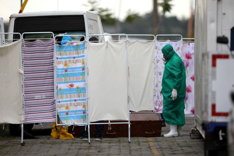 Foto del viernes de un trabajador con traje protector preparando ataúdes para transportar muertos en el hospital Dr. Joao Lucio Pereira Machado en Manaos en medio de la pendemia de coronavirus.
Abril 17, 2020. REUTERS/Bruno Kelly