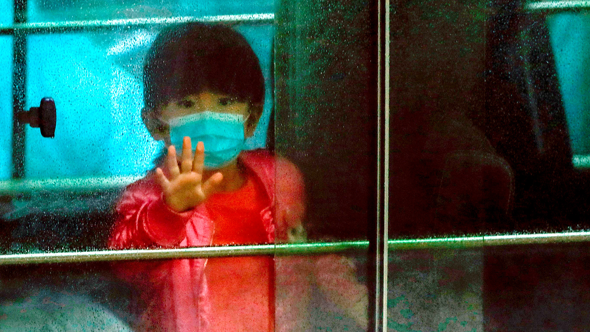 Una niña saluda mientras se sienta en un vehículo que transporta a los residentes evacuados de un edificio de viviendas públicas, en las afueras de la casa Hong Mei, en Cheung Hong Estate, en Hong Kong (REUTERS / Tyrone Siu)