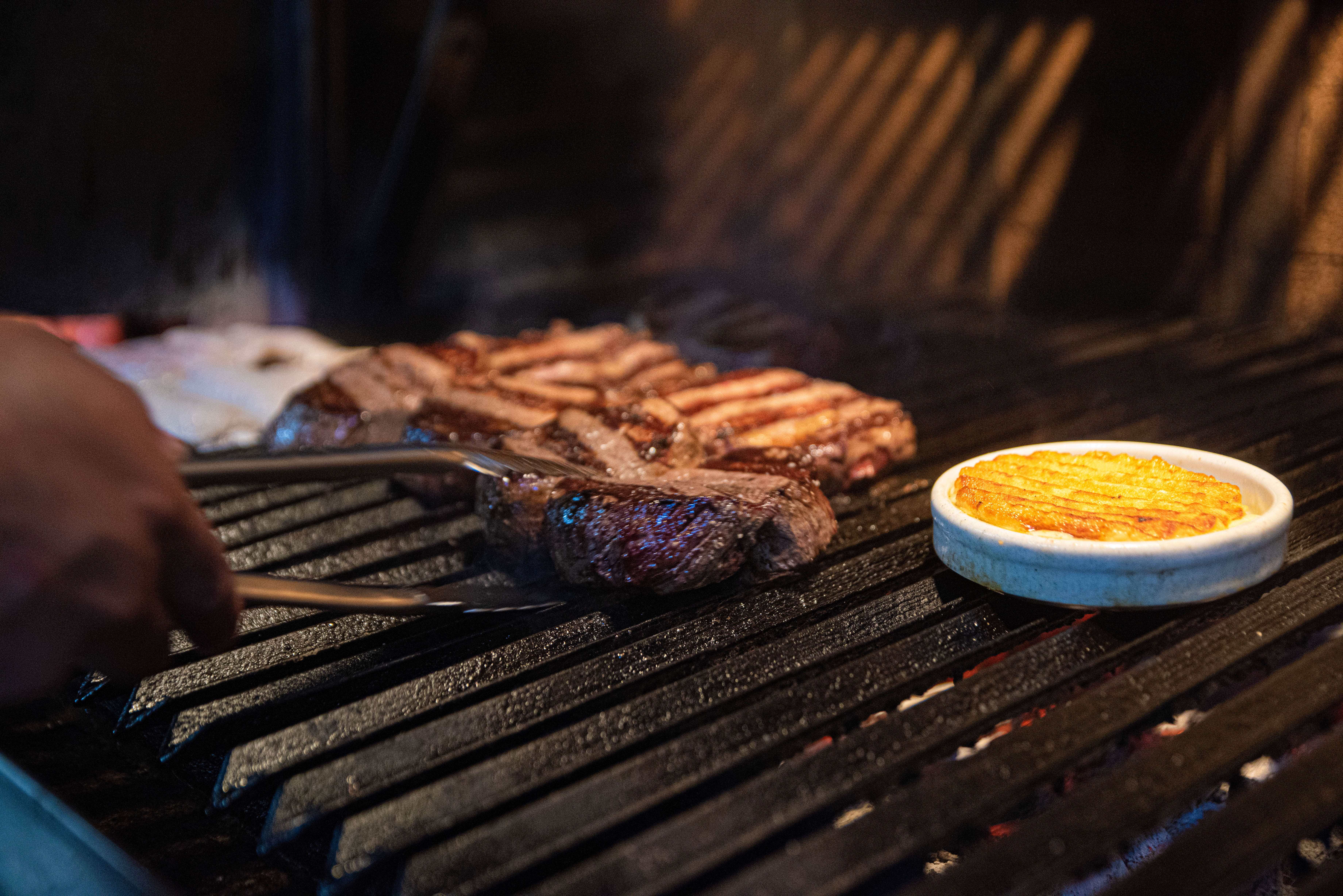 La parrilla está lista para ser servida. Provoleta y bife de chorizo, la estrella de la casa