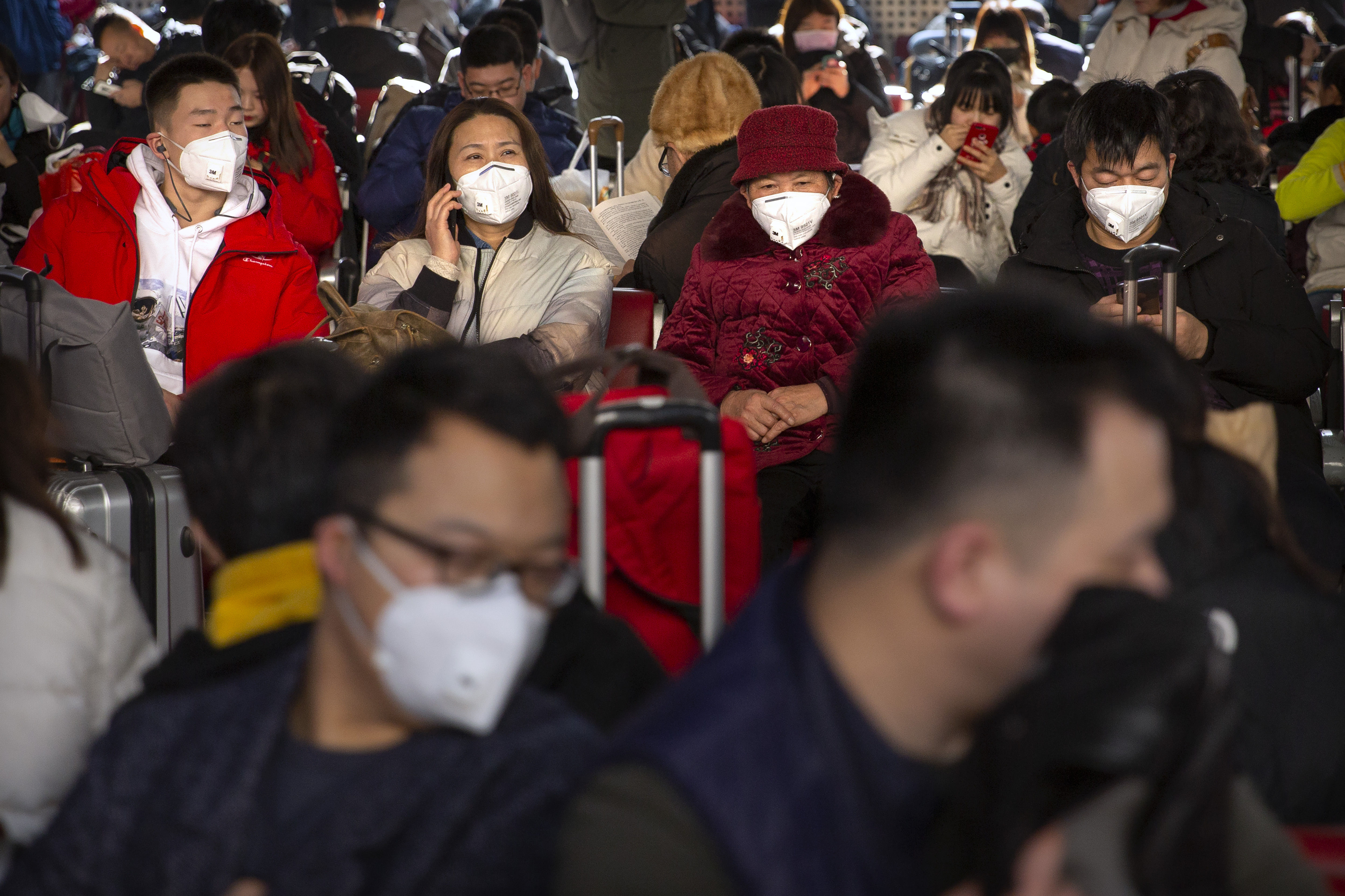 Los viajeros usan máscaras faciales mientras se sientan en una sala de espera en la Estación de Ferrocarril Oeste de Beijing en Beijing, el martes 21 de enero de 2020. Una cuarta persona murió en un brote de un nuevo coronavirus en China, dijeron las autoridades el martes. intensificó el examen médico de los viajeros del país a medida que entra en su período de mayor actividad. (Foto AP / Mark Schiefelbein)