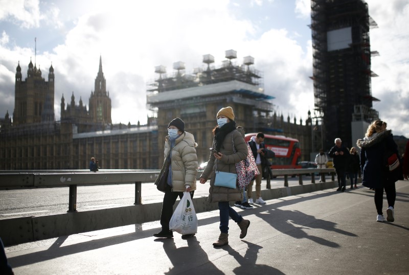 El Parlamento británico es visto mientras personas con máscaras protectoras caminan a través del puente de Westminster, mientras el número de casos de coronavirus (COVID-19) continúa creciendo (REUTERS/Henry Nicholls)