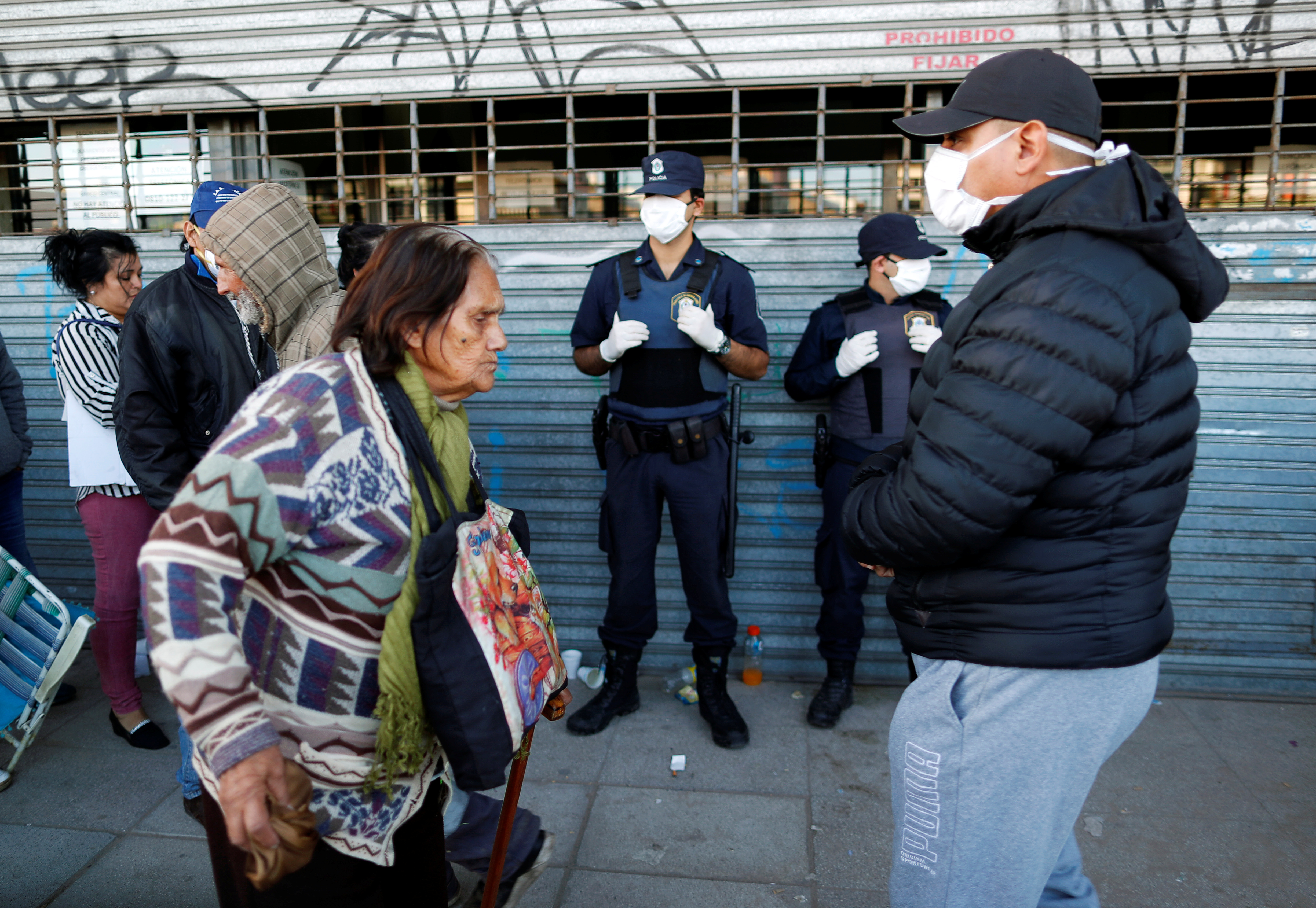 Retirees and people on welfare plans queue outside a bank, as it opened for first time since the mandatory quarantine due to the coronavirus disease (COVID-19), in Buenos Aires, Argentina April 3, 2020. REUTERS/Agustin Marcarian