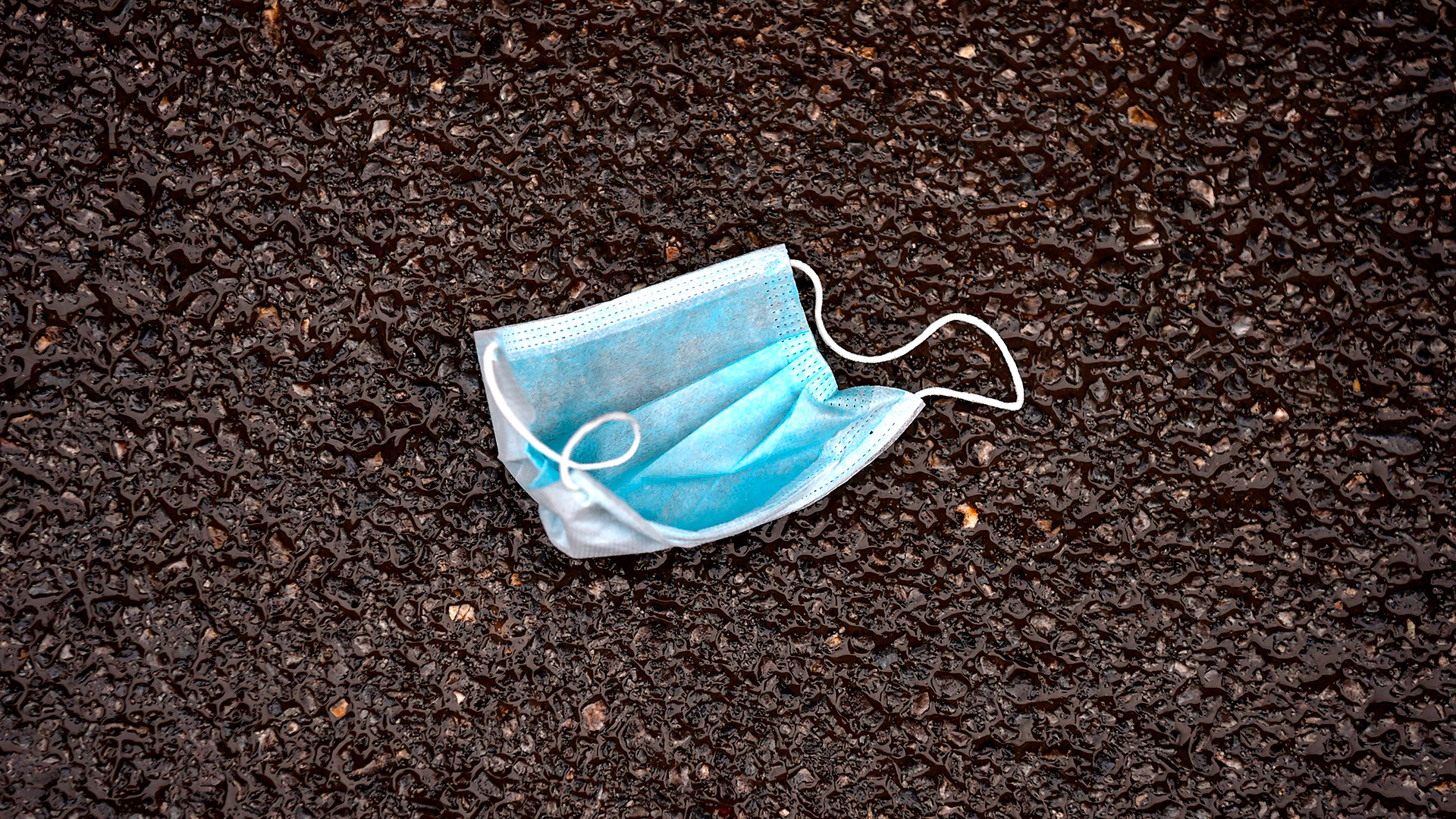 Una máscara facial descartada se encuentra en una calle en Wuhan el 26 de enero de 2020 (Héctor RETAMAL / AFP)