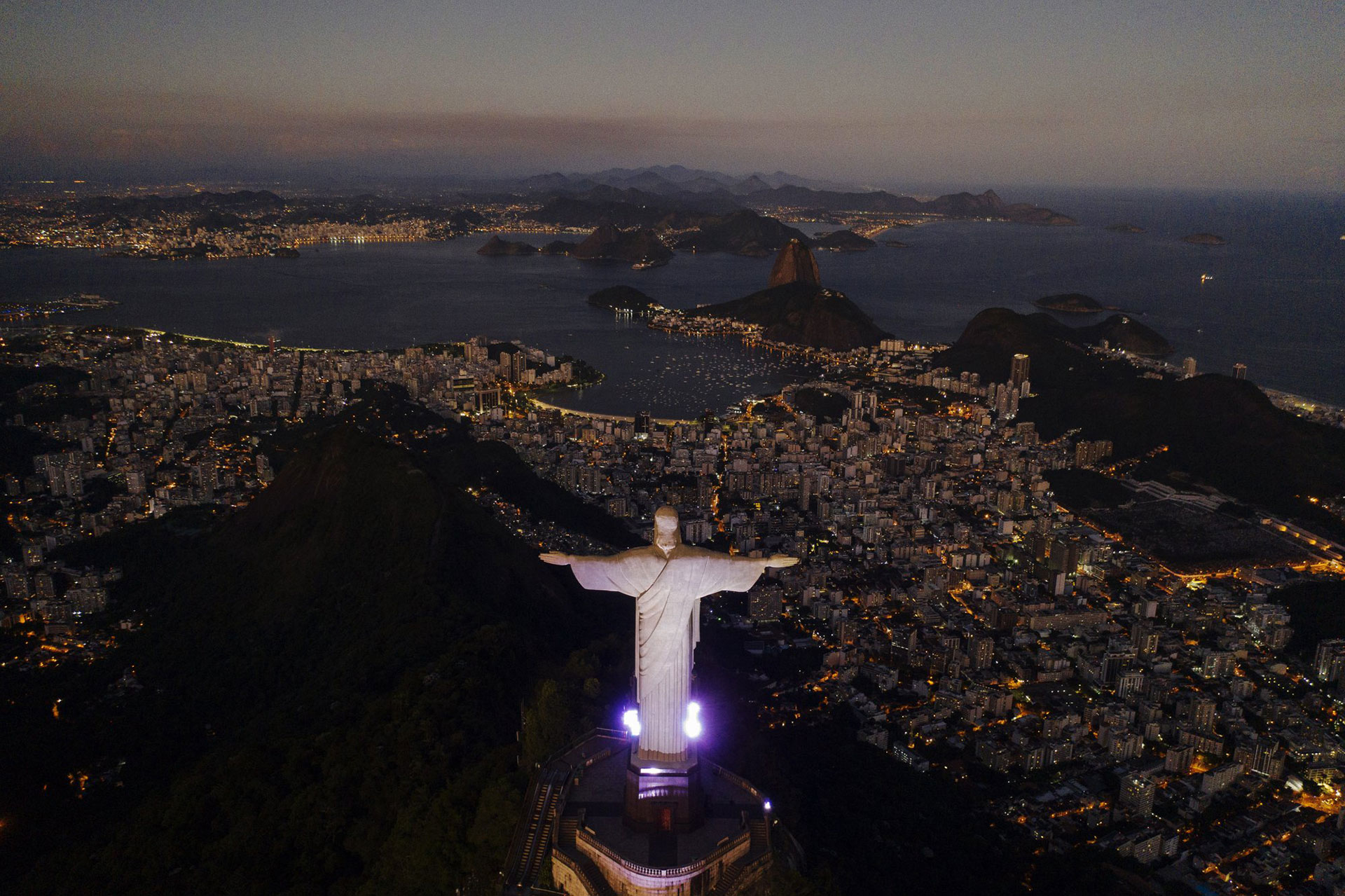 La estatua del Cristo Redentor se alza sobre la bahía de Guanabara durante el anochecer en medio del brote del coronavirus en Río de Janeiro, Brasil, el lunes 27 de abril de 2020. (Foto AP / Leo Correa)