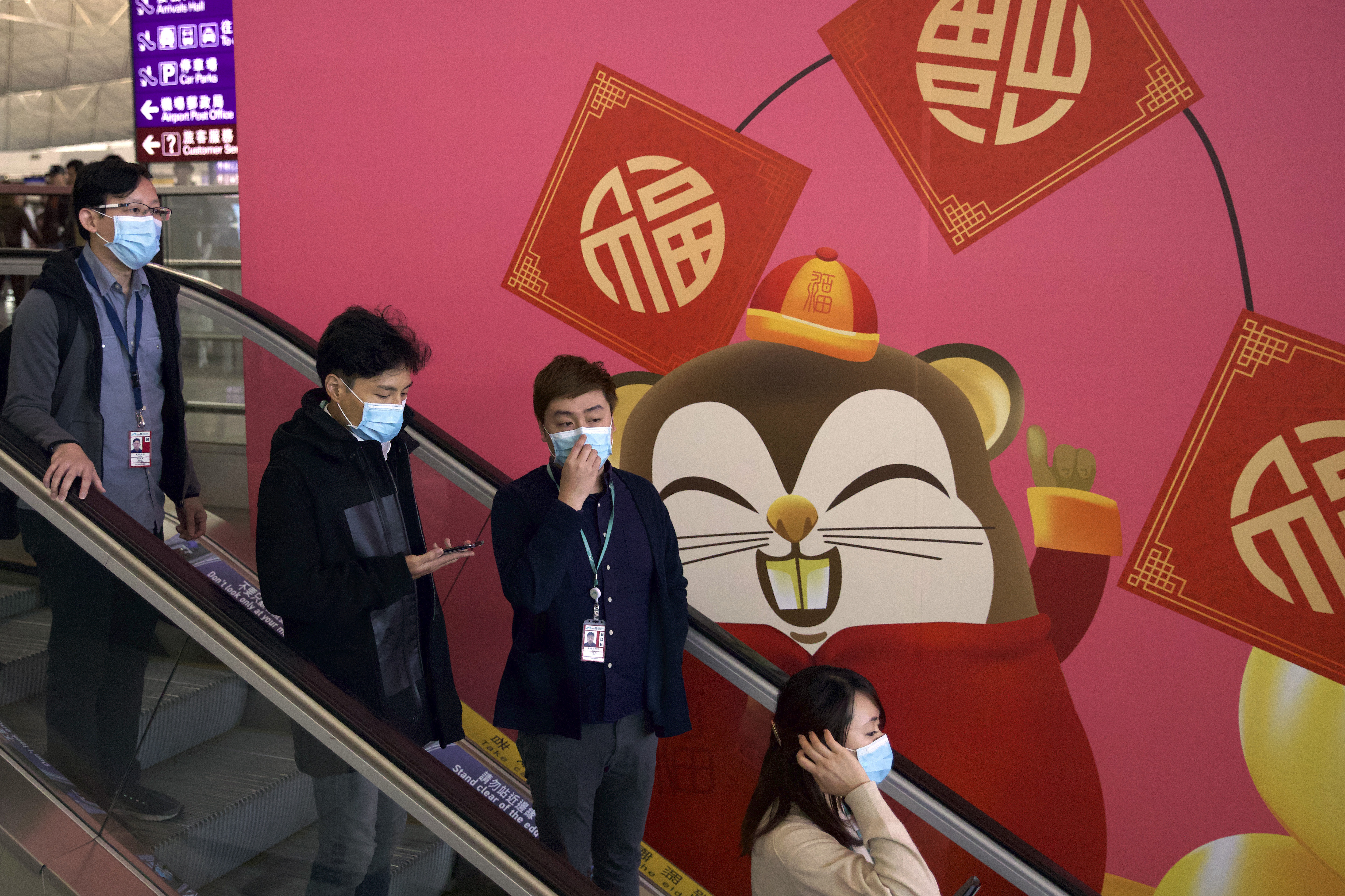 Viajeros usan máscaras faciales mientras suben por una escalera mecánica en el Aeropuerto Internacional de Hong Kong en Hong Kong, el martes 21 de enero de 2020. (Foto AP / Ng Han Guan)