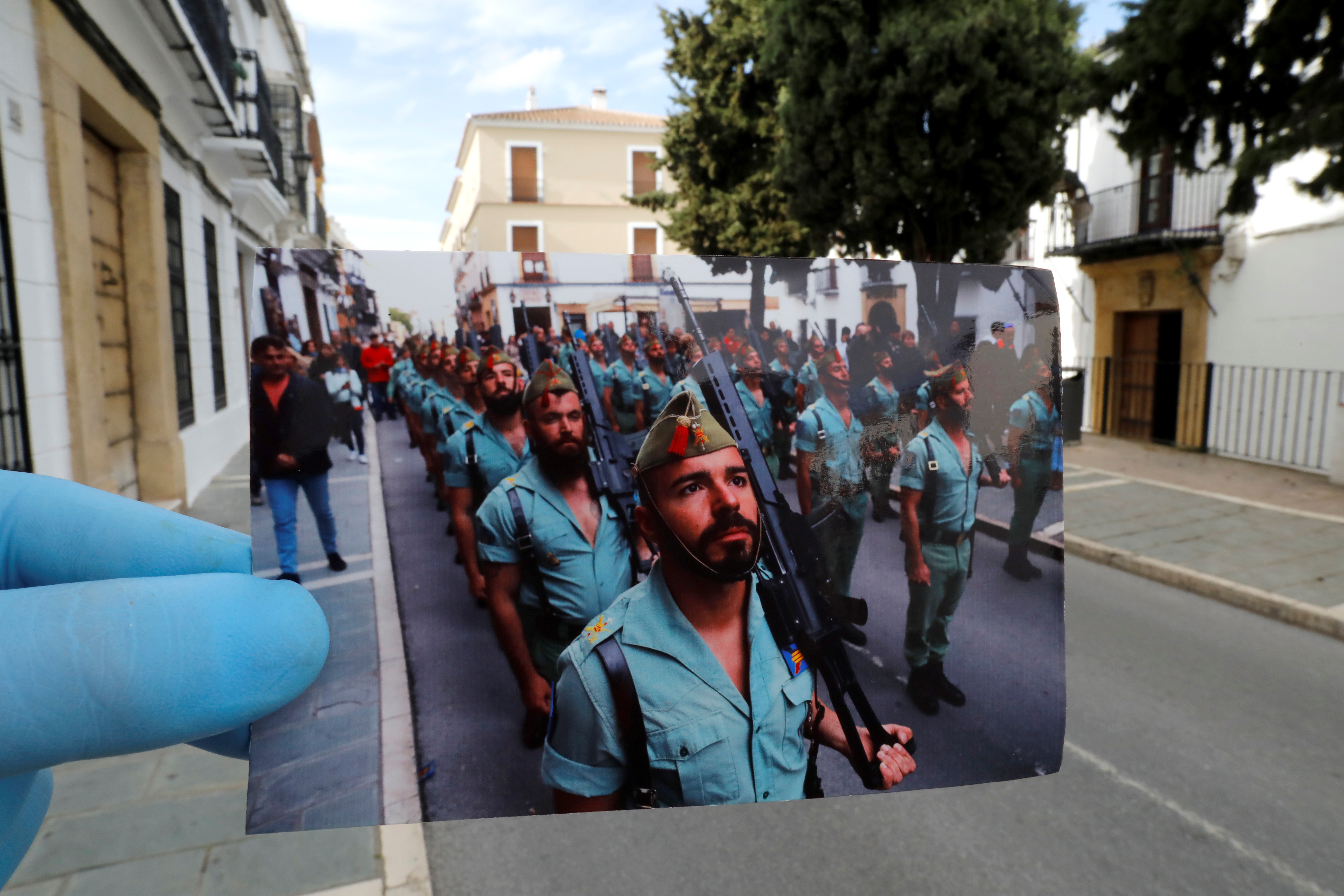 Un fotógrafo sostiene una imagen de 2019 en el mismo lugar donde fue capturada, ahora vacío por las medidas de confinamiento