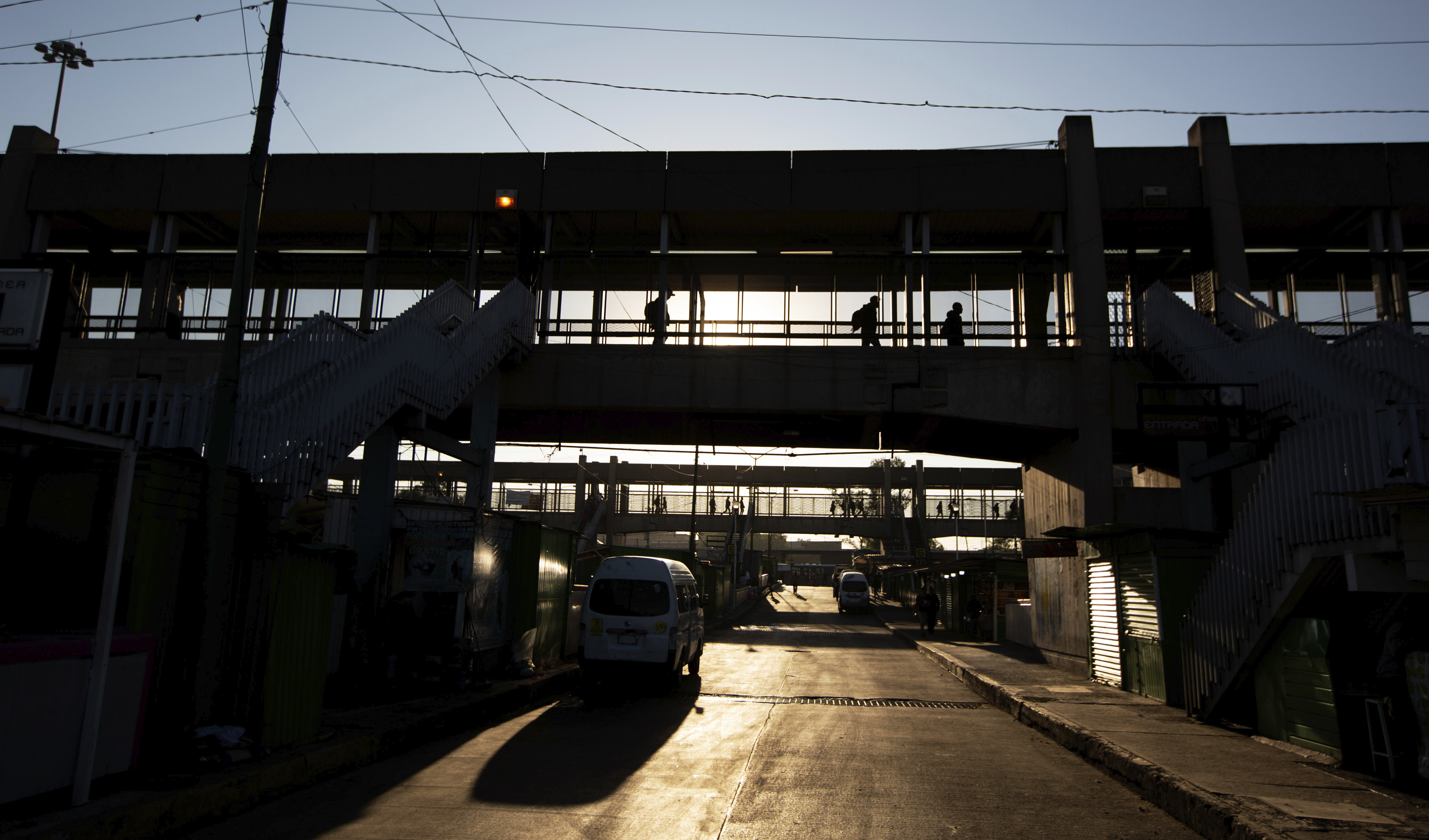 Viajeros del metro caminan por un puente peatonal con el cielo matutino en la Ciudad de México, el miércoles 25 de marzo de 2020. La capital de México ha cerrado museos, bares, gimnasios, iglesias, teatros y otros negocios no esenciales que reúnen una gran cantidad de personas, en un intento por frenar la propagación del nuevo coronavirus.