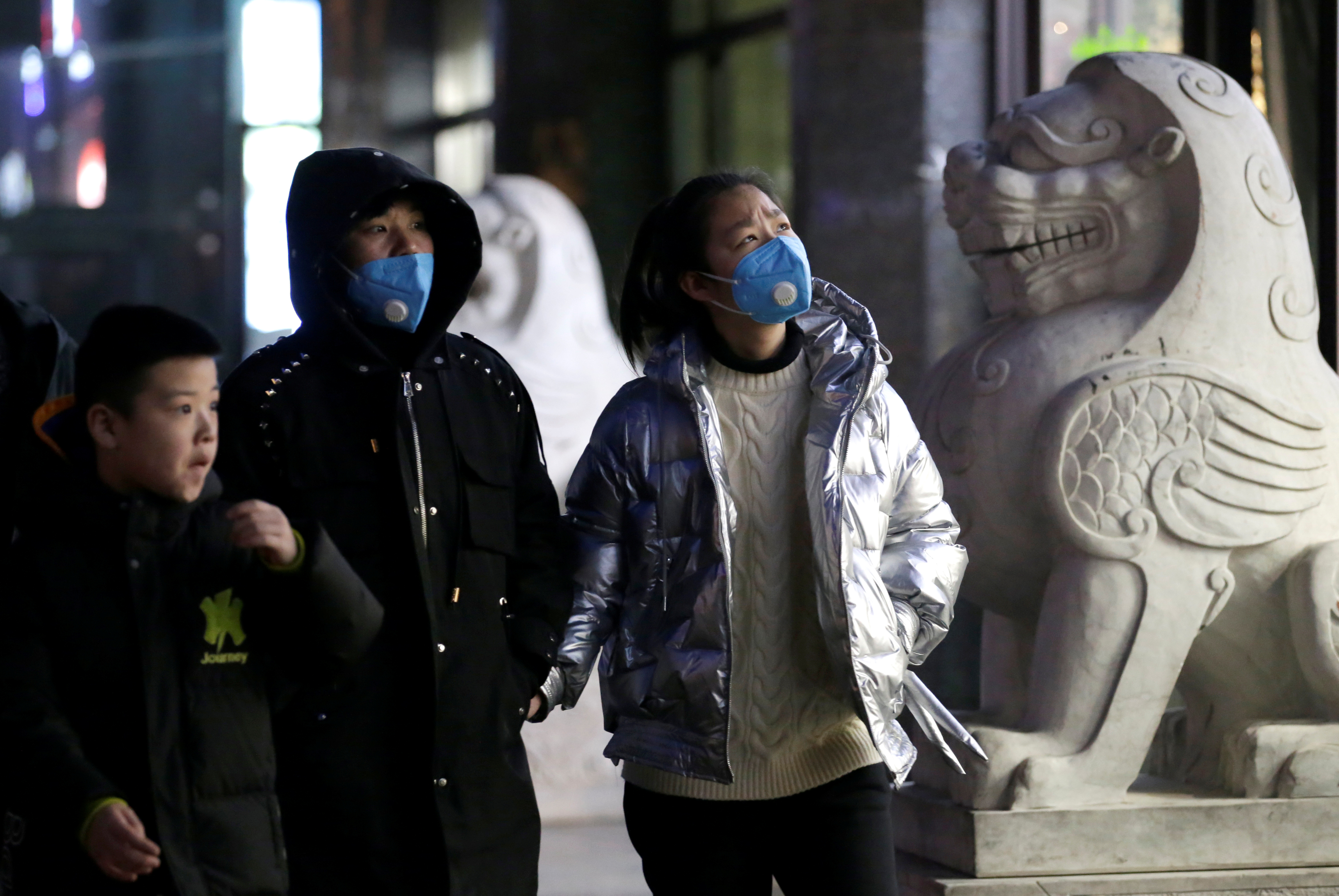 Personas con máscaras caminan por una calle en Beijing, China, 21 de enero de 2020. REUTERS / Jason Lee