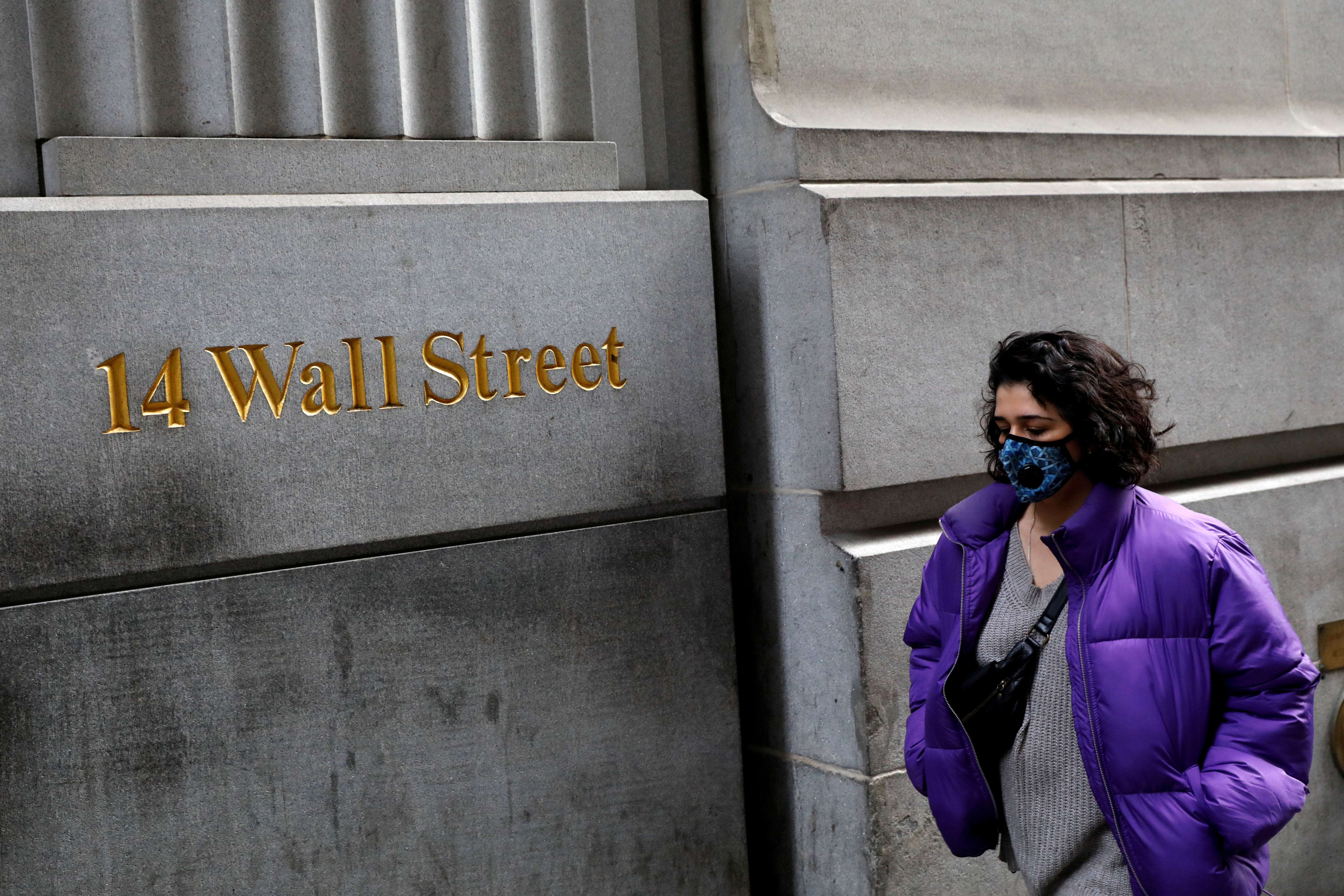 Una mujer con mascarilla camina por el distrito financiero de Nueva York (Reuters)