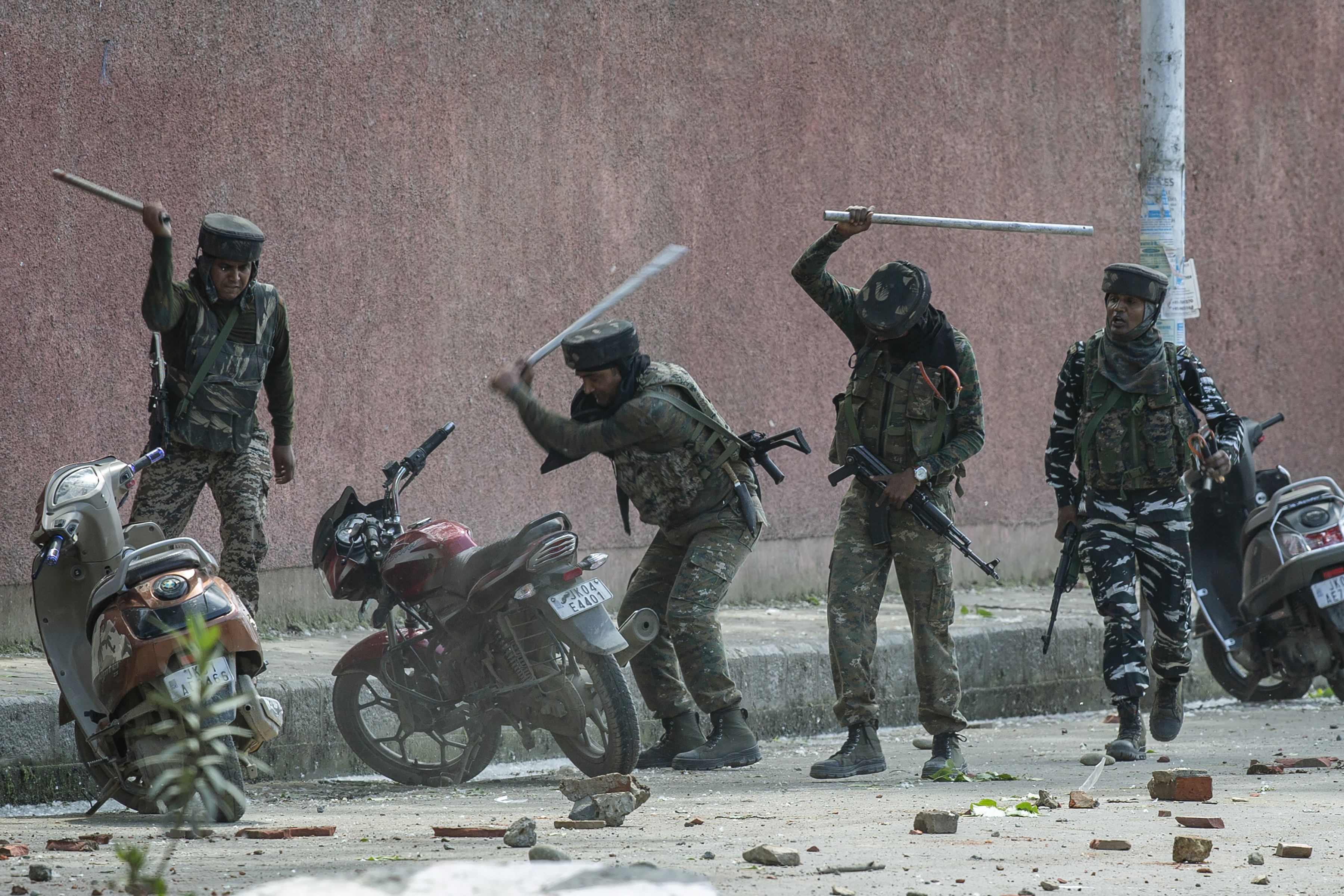 Soldados paramilitares indios rompen motocicletas estacionadas afuera de una universidad mientras chocan con estudiantes que protestaban por la presunta violación de una niña de 3 años en Srinagar, Cachemira controlada por la India, 14 de mayo de 2019. (Foto AP / Dar Yasin)