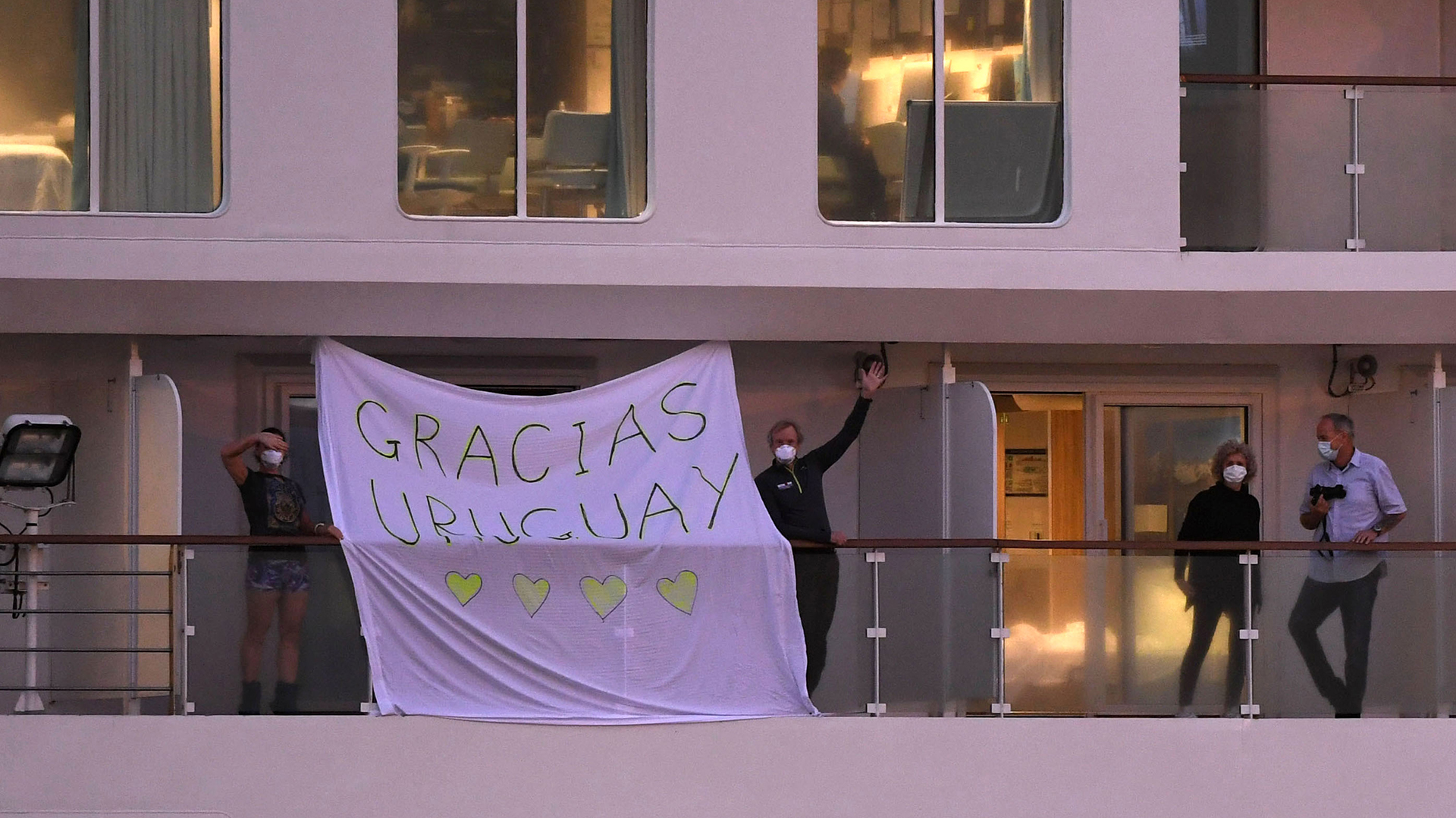 Los pasajeros del buque australiano afectado por el virus colgaron una bandera en agradecimiento a Uruguay (AFP)