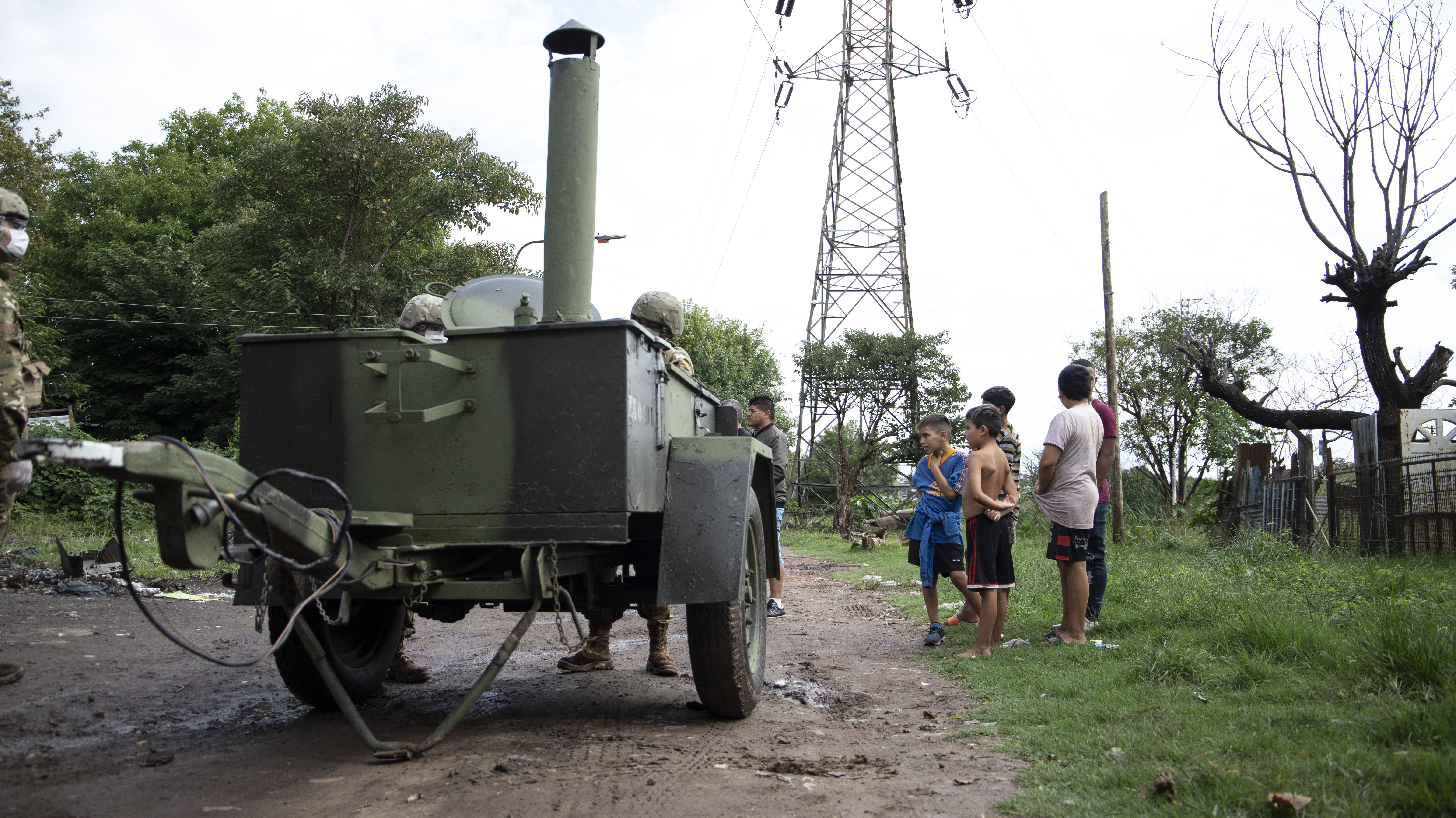Un grupo de chicos espera un plato de comida en uno de los puntos de concentración del campamento militar
