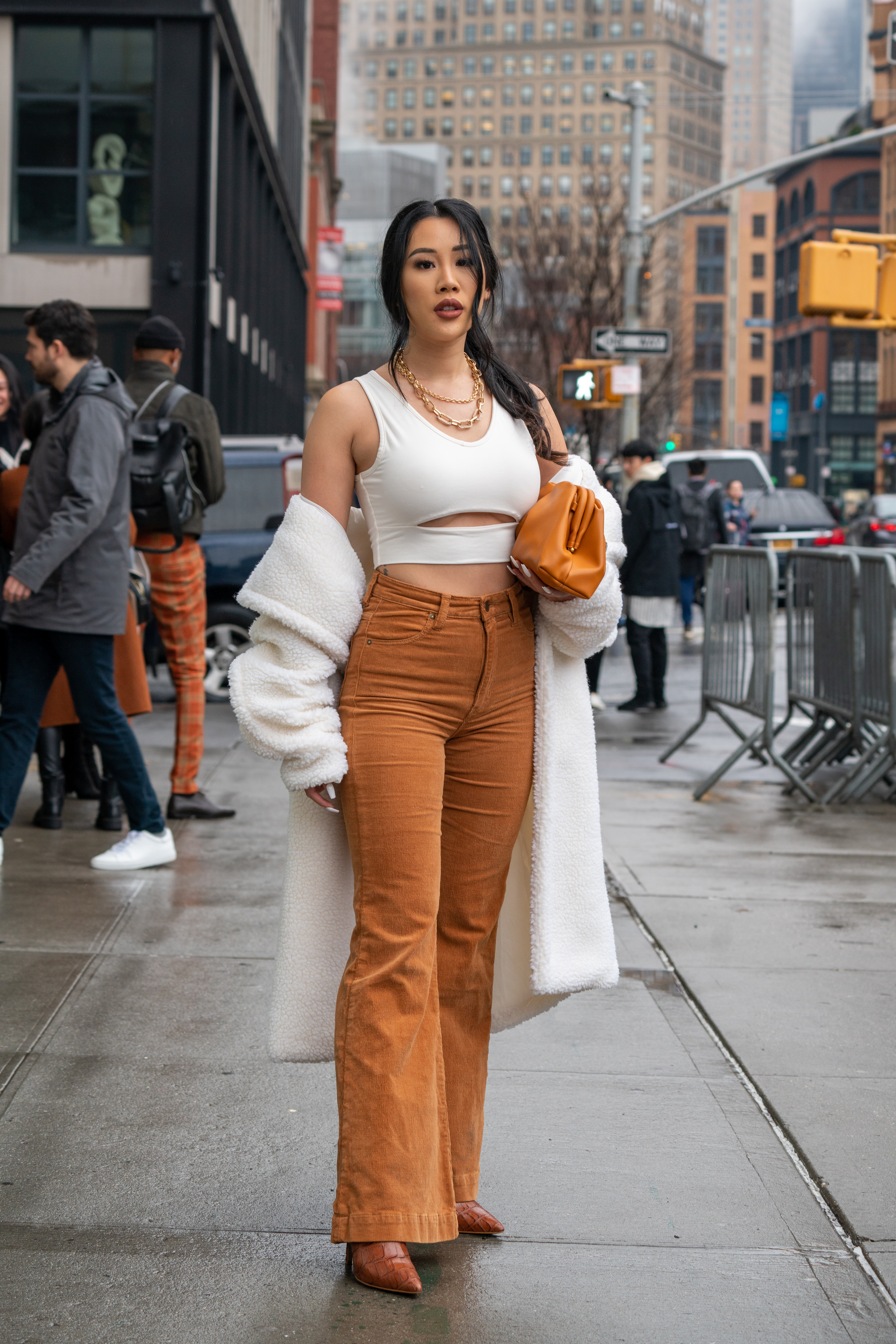 Con crop top, pantalón de gabardina en color dulce de leche de tiro alto, con botas de croco y tapado de peluche. Como accesorios para el street style optó por cadenas de oro y un bolso beige