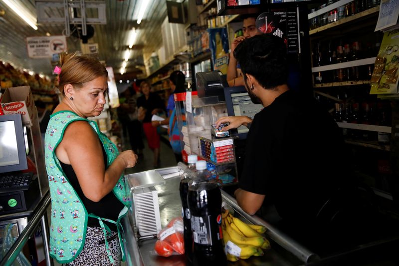 Foto de archivo. Una mujer paga sus compras al cajero en un supermercado en Caracas, Venezuela. 23 de marzo de 2019. REUTERS/Carlos Garcia Rawlins.
