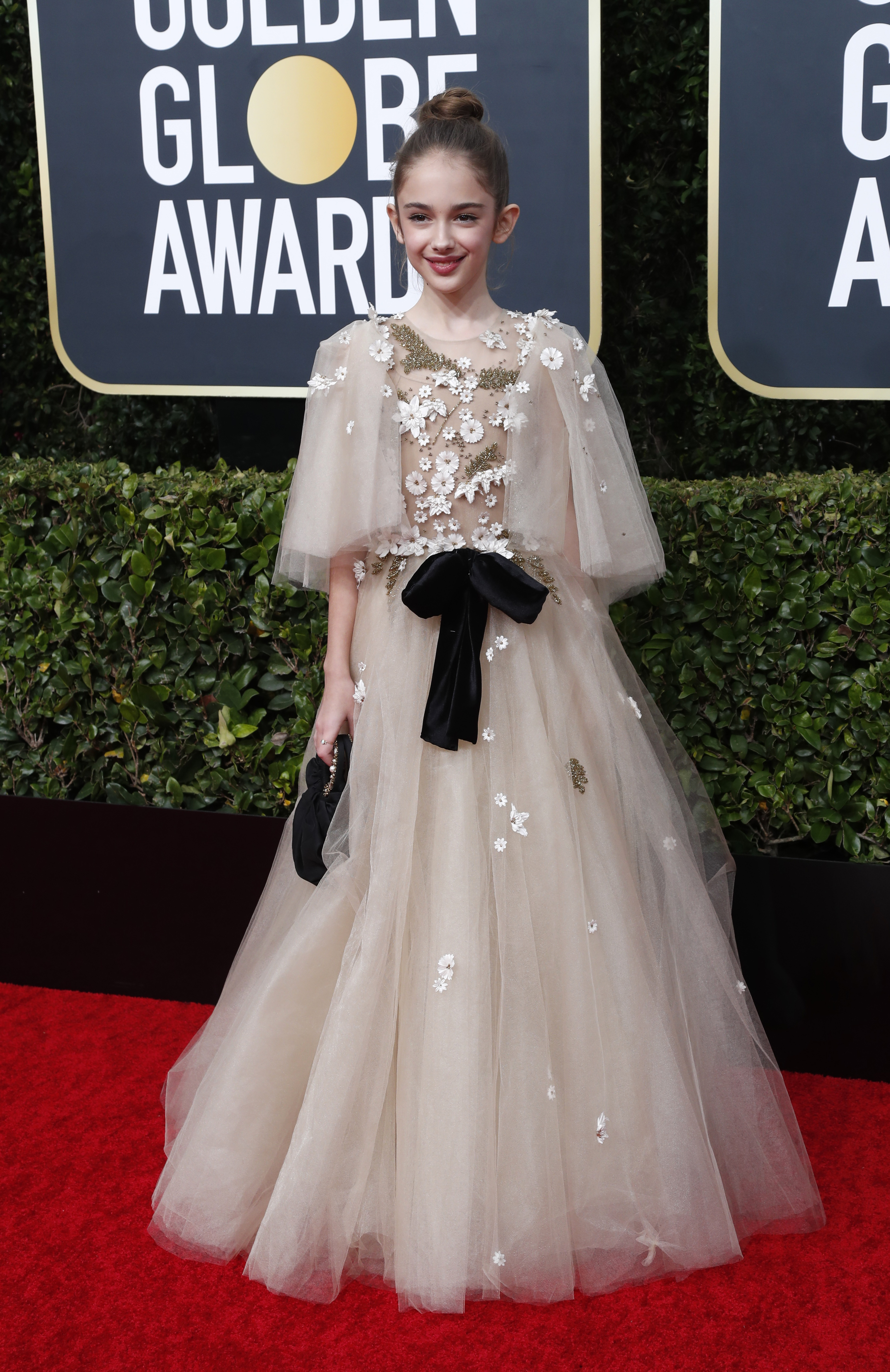 La pequeña actriz Julia Butters, en sus primeros Golden Globes, lució un vestido estilo romántico con detalles de apliques de flores de margaritas y cintas de chiffón