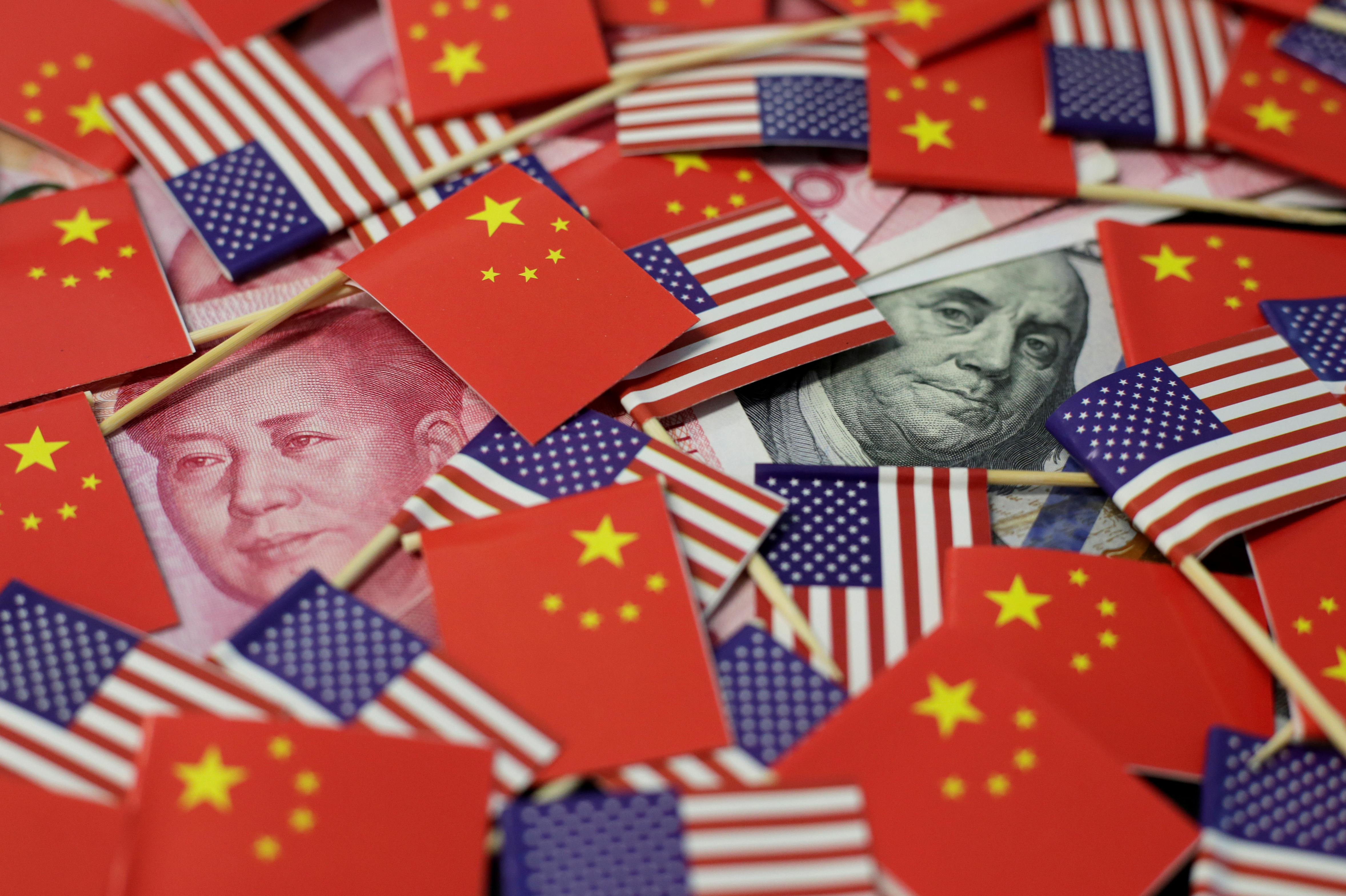 Imagen de archivo de billetes de dólar y yuan bajo banderas de EEUU y China (Foto: Reuters)