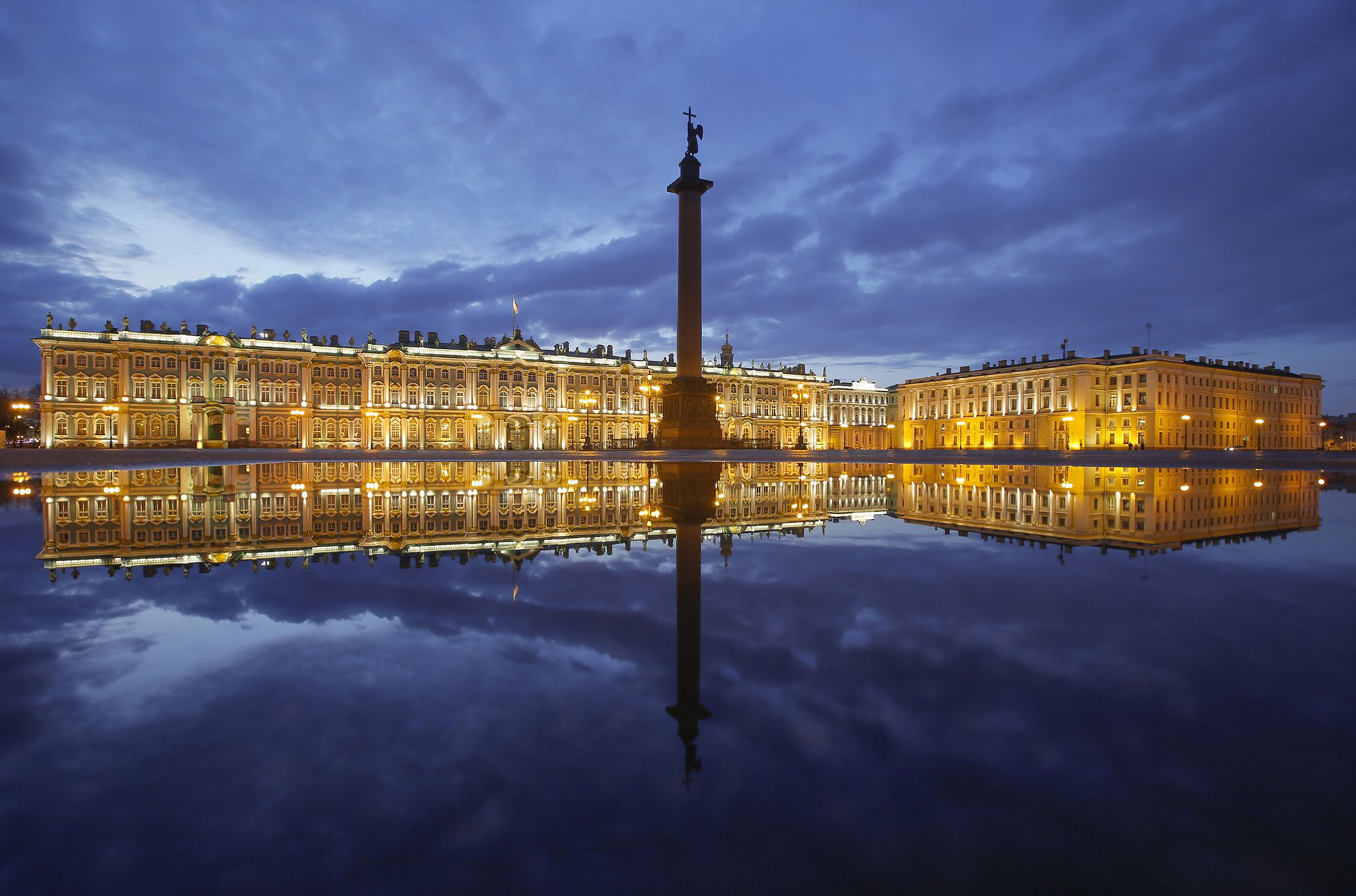 El Palacio de Invierno y la Columna de Alejandro se reflejan en un charco después de la lluvia en la Plaza del Palacio en San Petersburgo, Rusia, el lunes 27 de abril de 2020. (Foto AP / Dmitri Lovetsky)