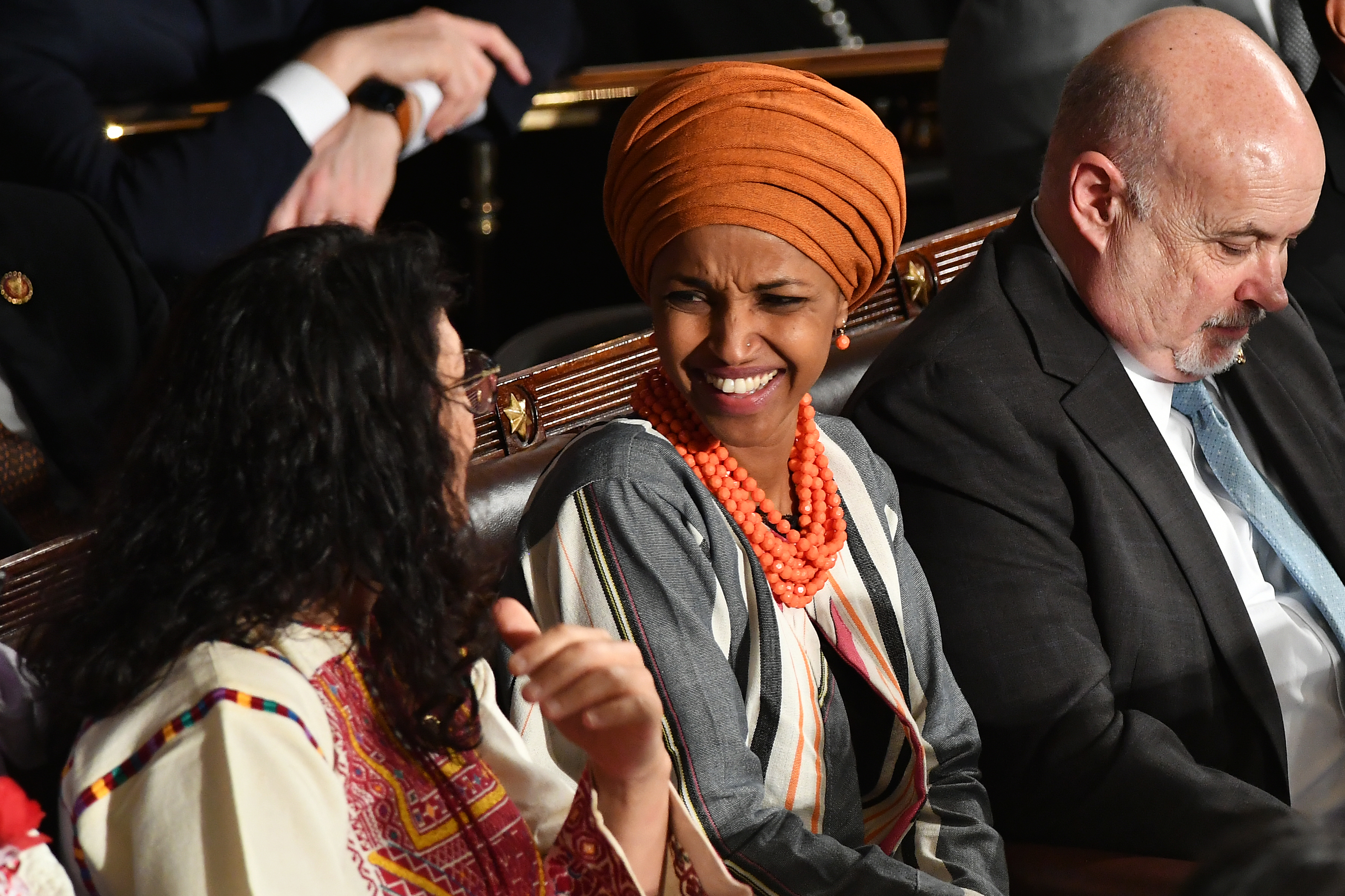 La congresista de Minnesota Ilhan Omar (derecha) y la congresista de Michigan Rashida Tlaib sonríen el presidente de los Estados Unidos, Donald Trump, pronuncia el discurso. (MANDEL NGAN / AFP)