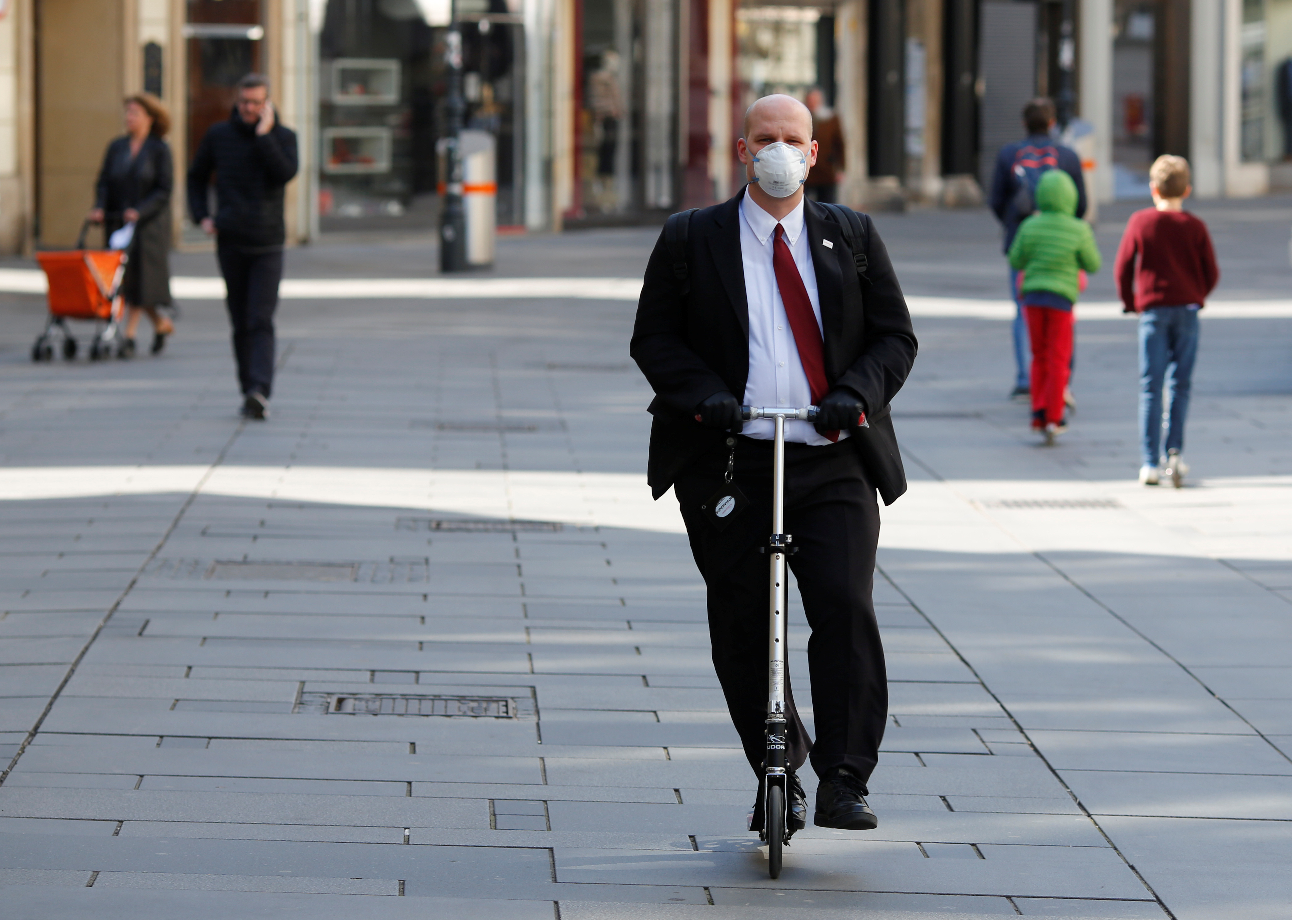 Un hombre con una mascarilla maneja un scooter en Viena, Austria (REUTERS/Leonhard Foeger)