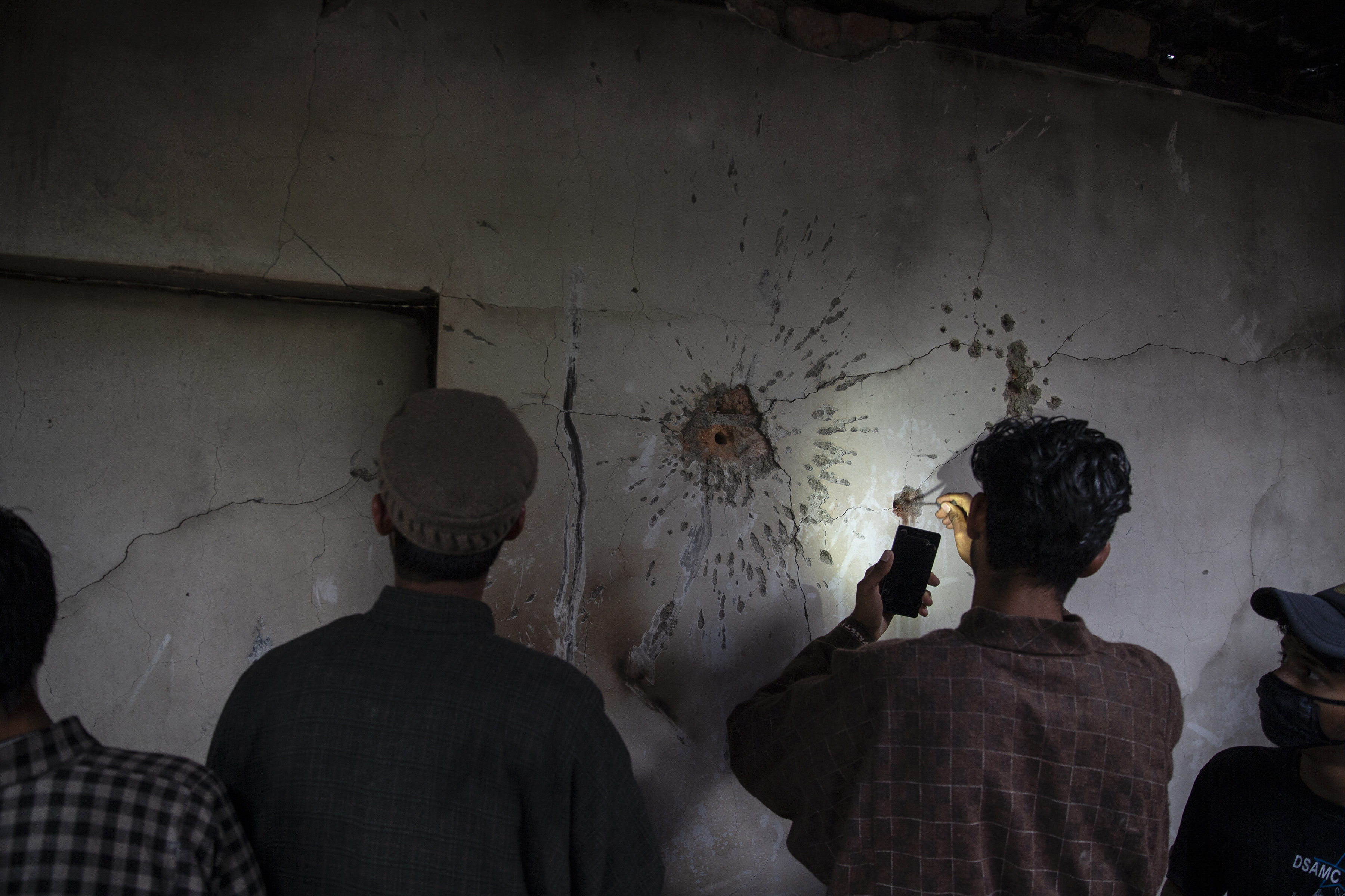 Un niño de Cachemira intenta sacar una bala de la pared de una casa dañada después de un tiroteo en Tral, al sur de Srinagar, Cachemira, el 24 de mayo de 2019. (Foto AP / Dar Yasin)