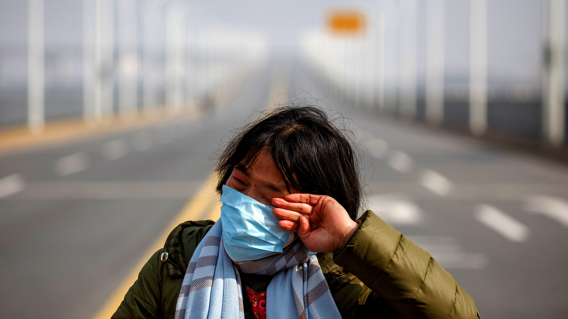 Una madre reacciona cuando le ruega a la policía que permita que su hija pase un punto de control para el tratamiento del cáncer después de llegar de la provincia de Hubei al puente del río Jiujiang Yangtze en Jiujiang, provincia de Jiangxi, China (REUTERS / Thomas Peter)