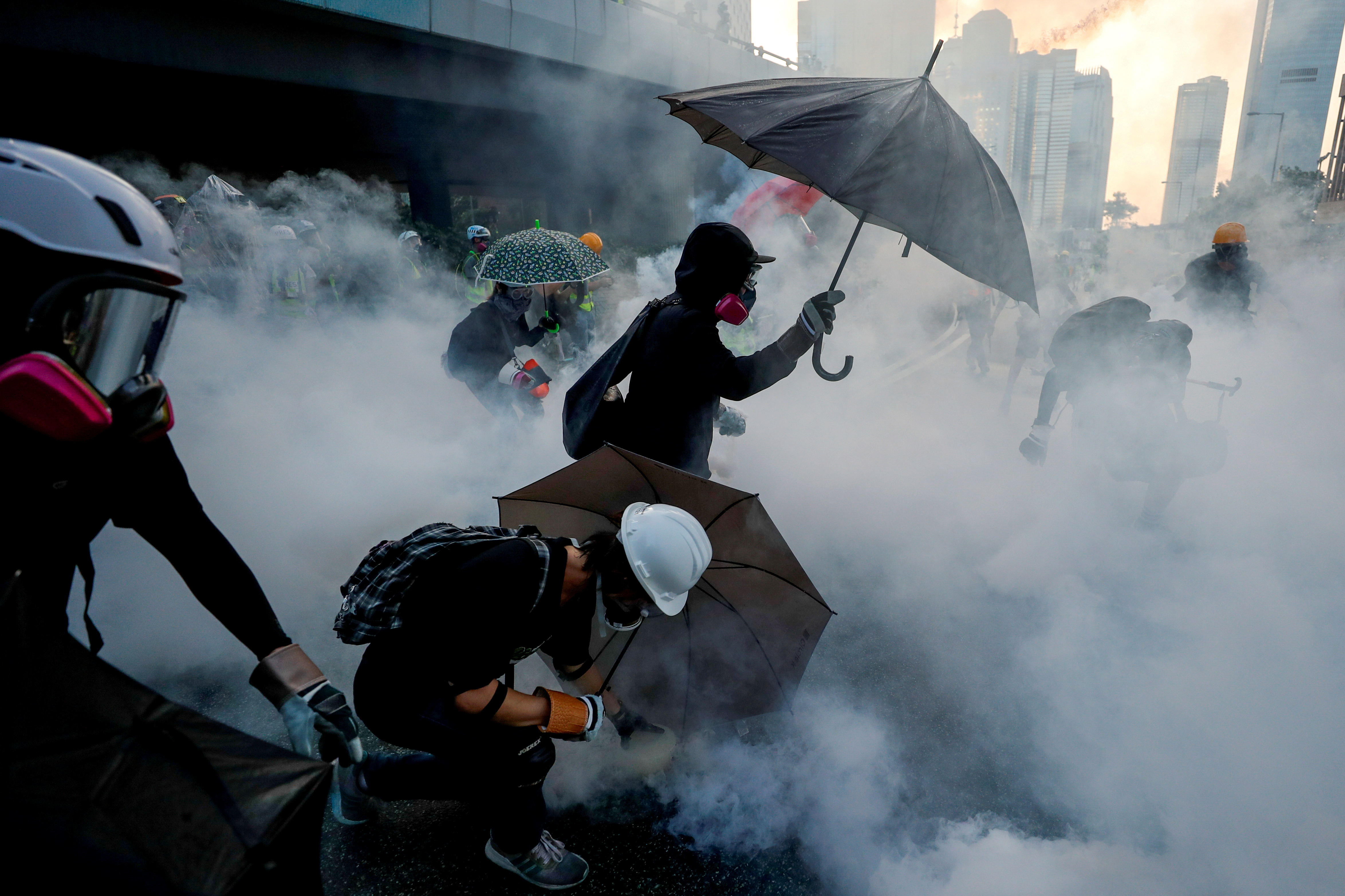 Manifestantes antigubernamentales se protegen con paraguas de los gases lacrimógenos durante una manifestación cerca del Complejo del Gobierno Central en Hong Kong, China, el 15 de septiembre de 2019 (REUTERS/Jorge Silva)