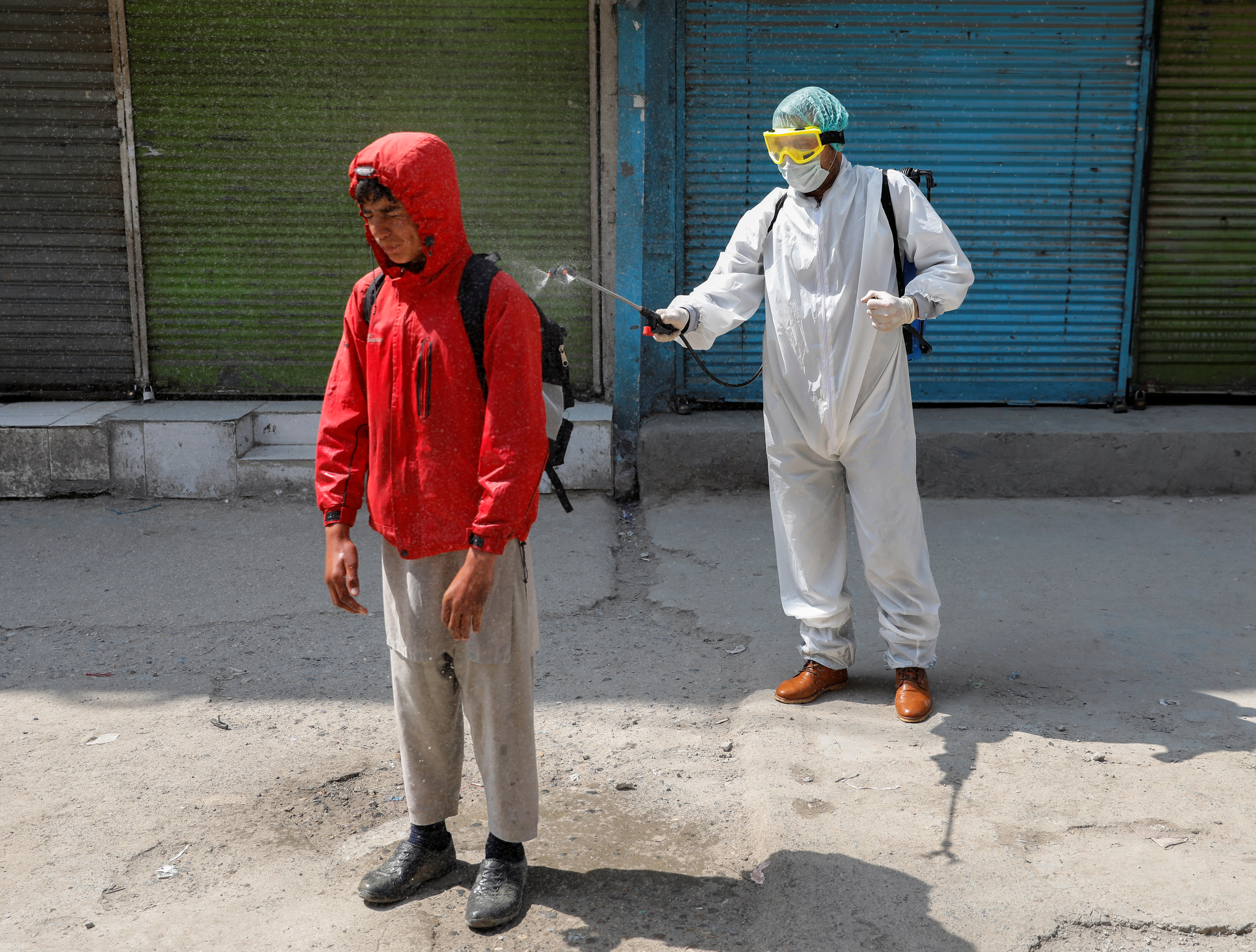 Un voluntario descontamina a personas en la calle