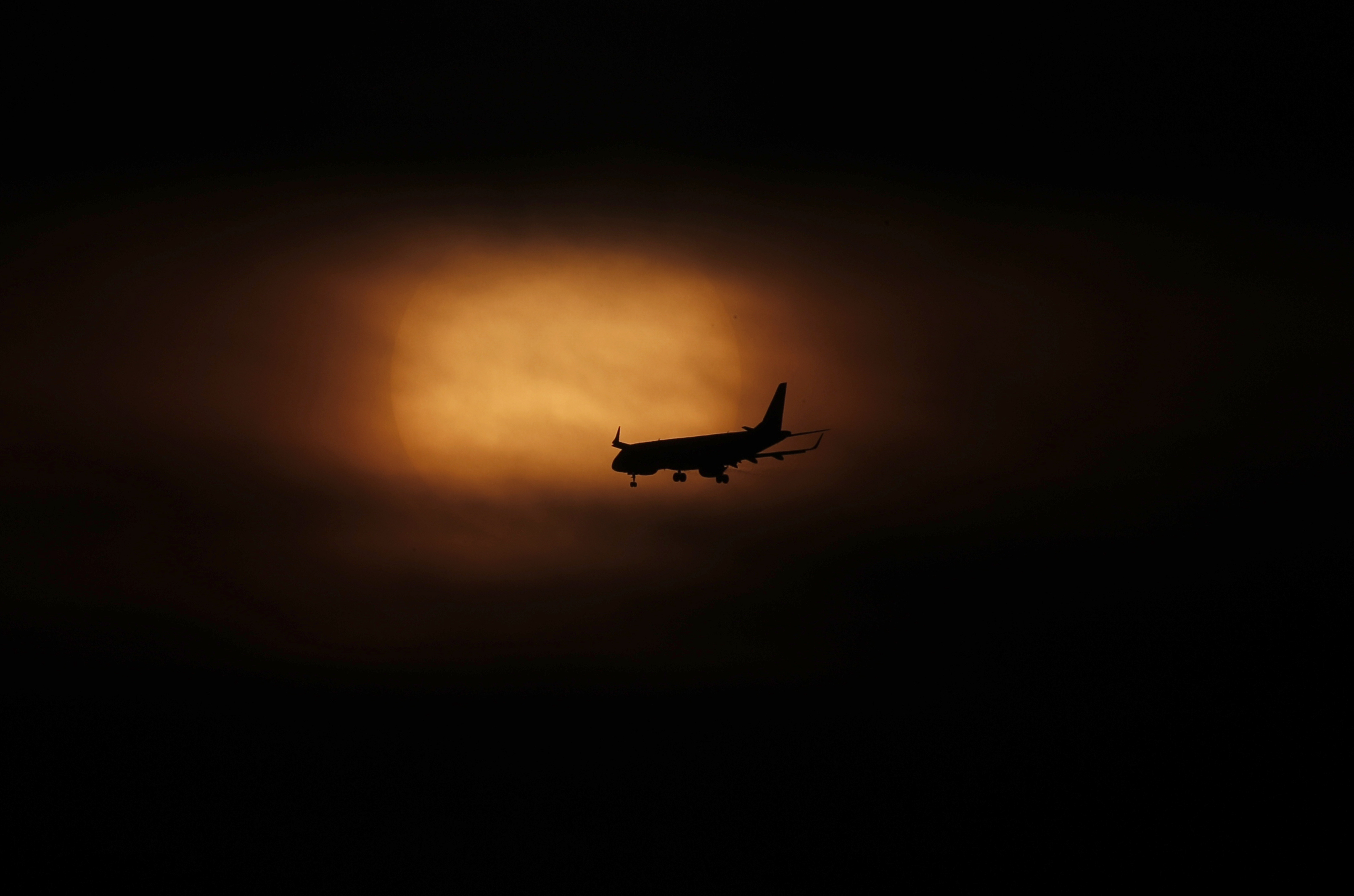 Un avión se prepara para aterrizar cuando sale el sol en la Ciudad de México, el sábado 21 de marzo de 2020.