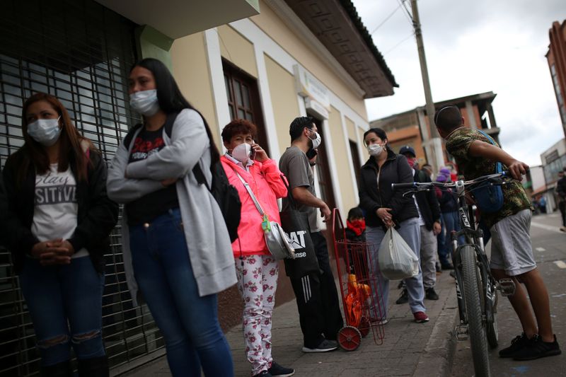 Personas usan máscarillas mientras hacen cola para ingresar a un supermercado durante el aislamiento obligatorio decretado por el gobierno colombiano, en Soacha.