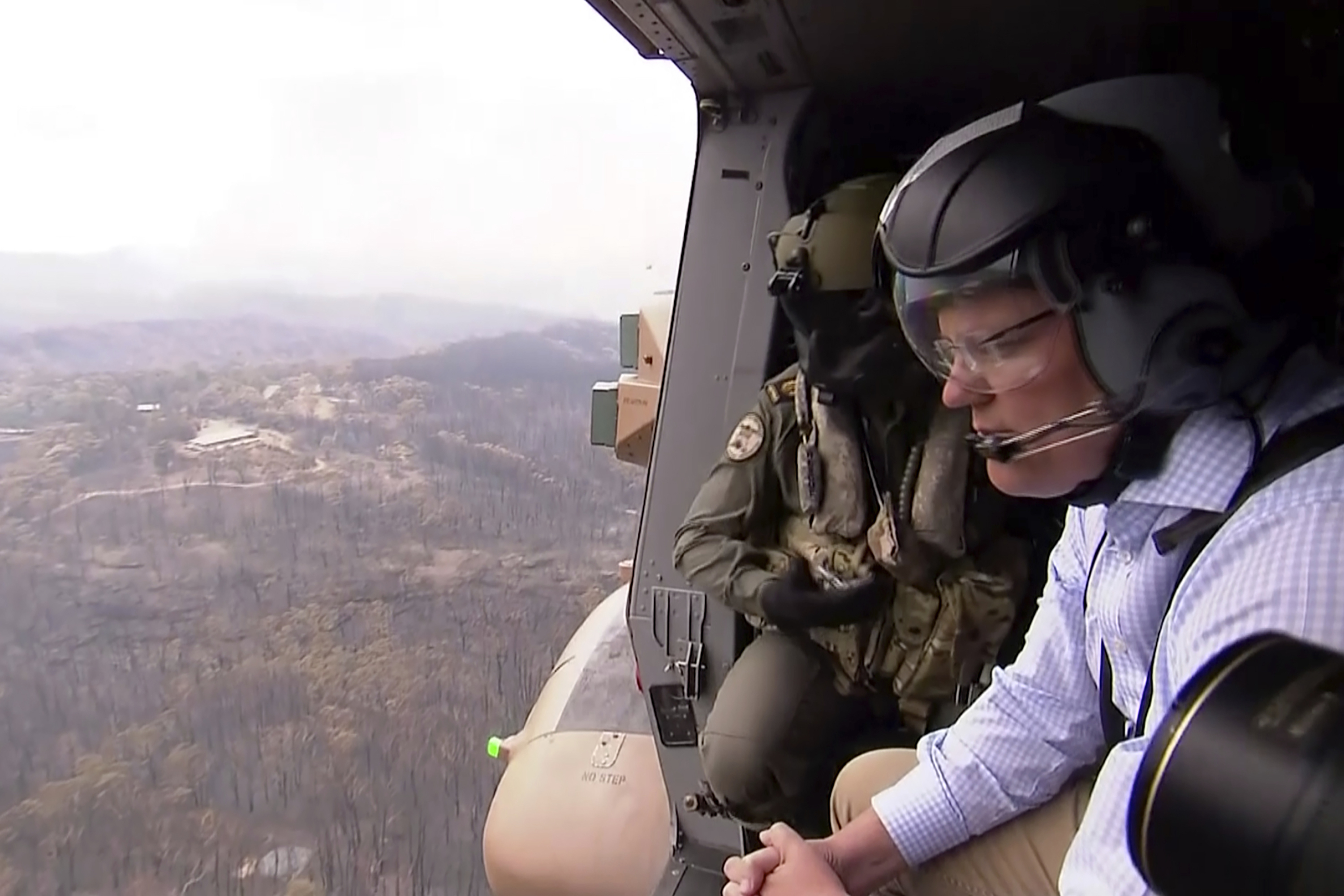 En esta imagen de archivo del 23 de diciembre de 2019, el primer ministro de Australia, Scott Morrison, analiza el daño desde un helicóptero cerca de Gospers Mountain, New South Wales. Morrison es blanco de críticas por su lenta reacción ante la devastación y por su mirada displicente sobre el cambio climático (AP)