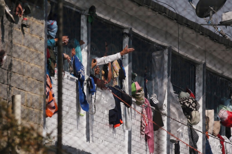 Reclusos sacan los brazos por las ventanas de sus celdas dentro de la prisión La Modelo después de un amotinamiento de reos que exigían al gobierno medidas sanitarias contra la propagación del (COVID-19), enfermedad provocada por el coronavirus, en Bogotá, Colombia. 22 de marzo, 2020. REUTERS/Leonardo Munoz NO DISPONIBLE PARA REVENTA. NO DISPONIBLE PARA ARCHIVO.