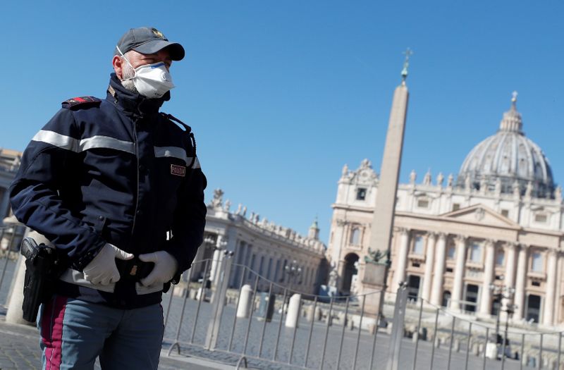 Un policía con mascarilla vigila la Plaza de San Pedro vacía en el Vaticano. (REUTERS/Guglielmo Mangiapane)