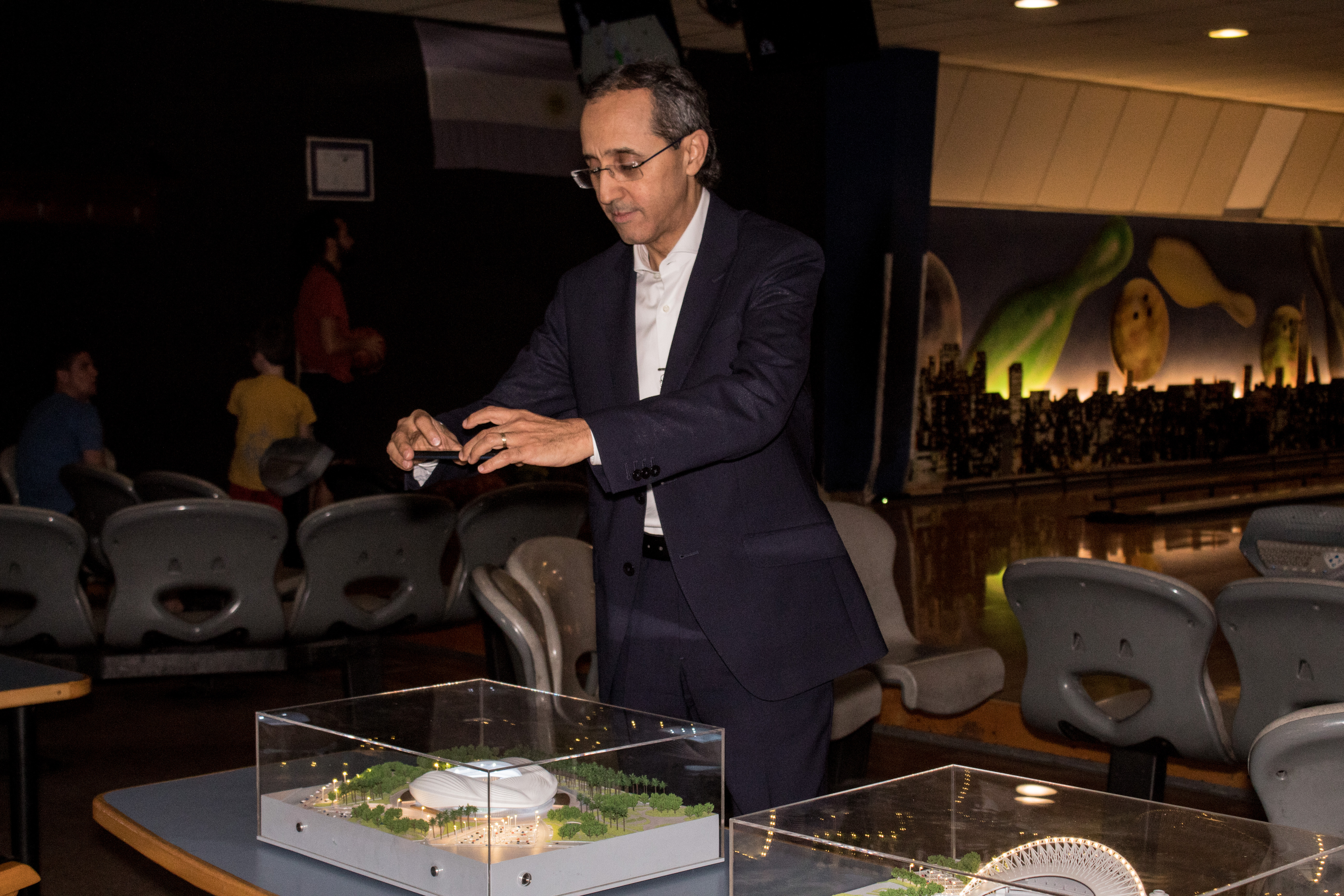 El embajador de Marruecos, Fares Yassir, toma una fotografía de una de las maquetas que se expusieron durante la celebración del Día Nacional del Deporte, con los estadios que actualmente se construyen en Qatar para la Copa del Mundo 2022