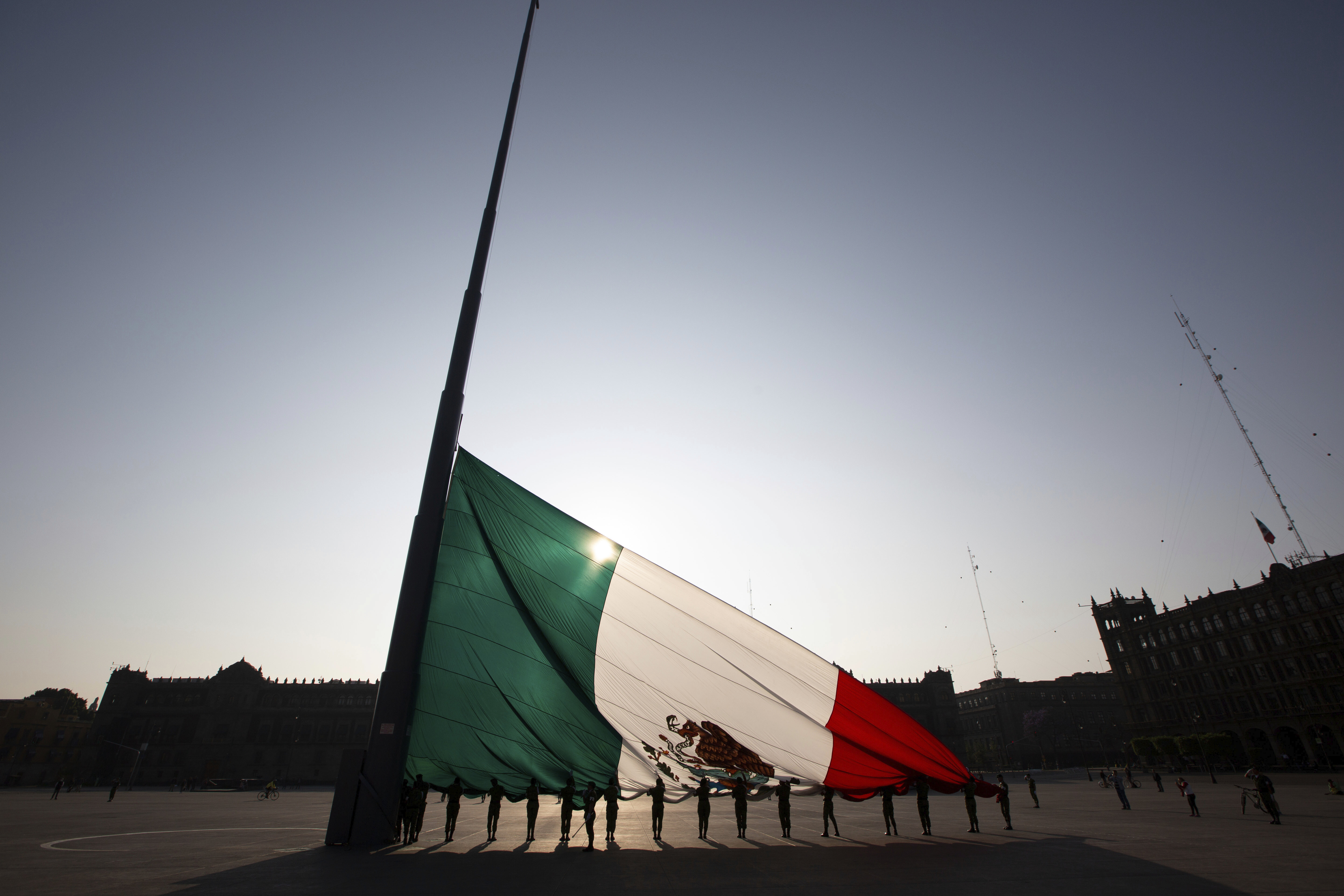 Los soldados mexicanos despliegan la bandera nacional en la plaza Zócalo en la Ciudad de México, el domingo 22 de marzo de 2020.