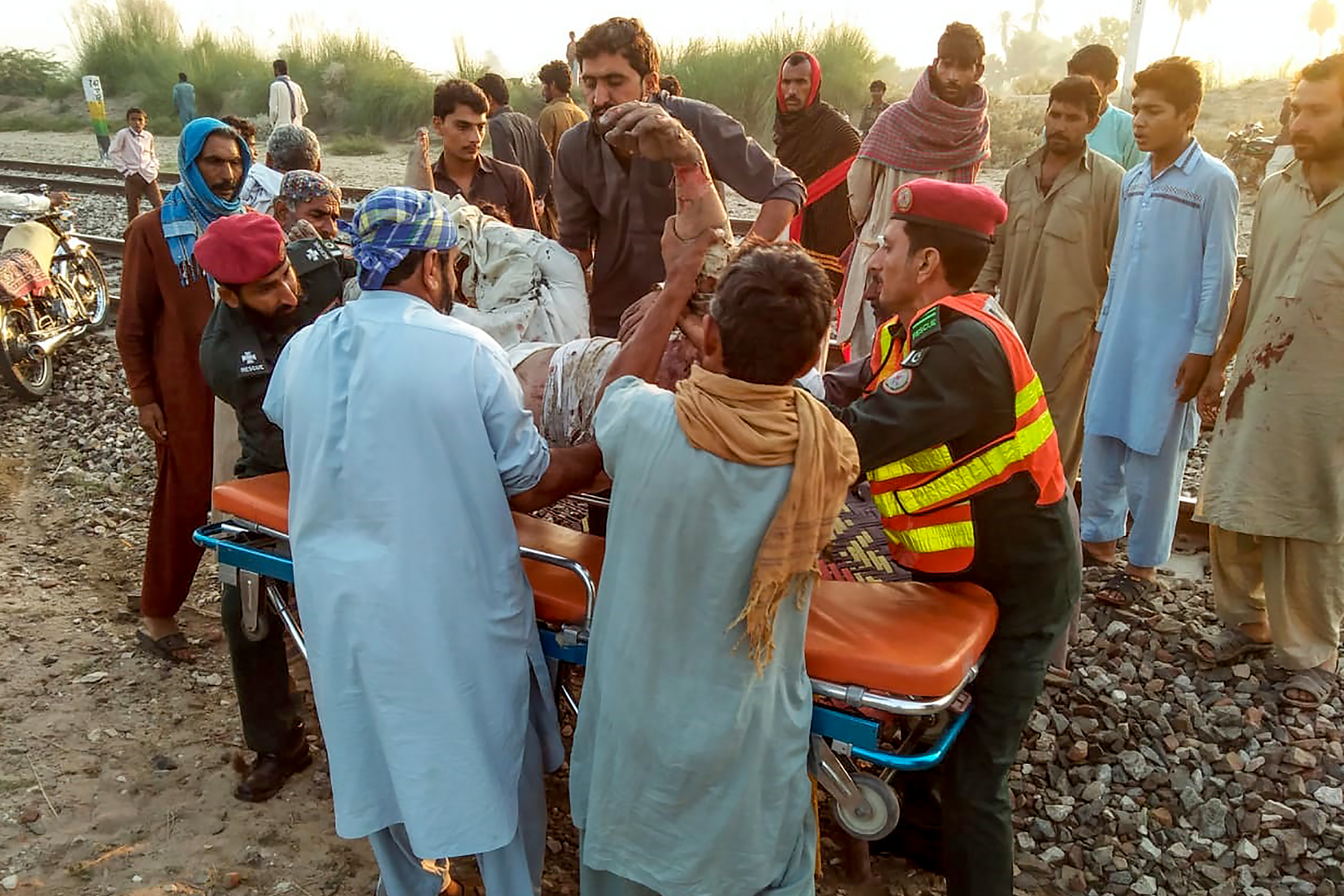 Los equipos de rescate mueven a una víctima herida en el sitio después de que un tren de pasajeros se incendió cerca de Rahim Yar Khan en la provincia de Punjab. (AFP / Servicio de Emergencia de Punjab de Pakistán)