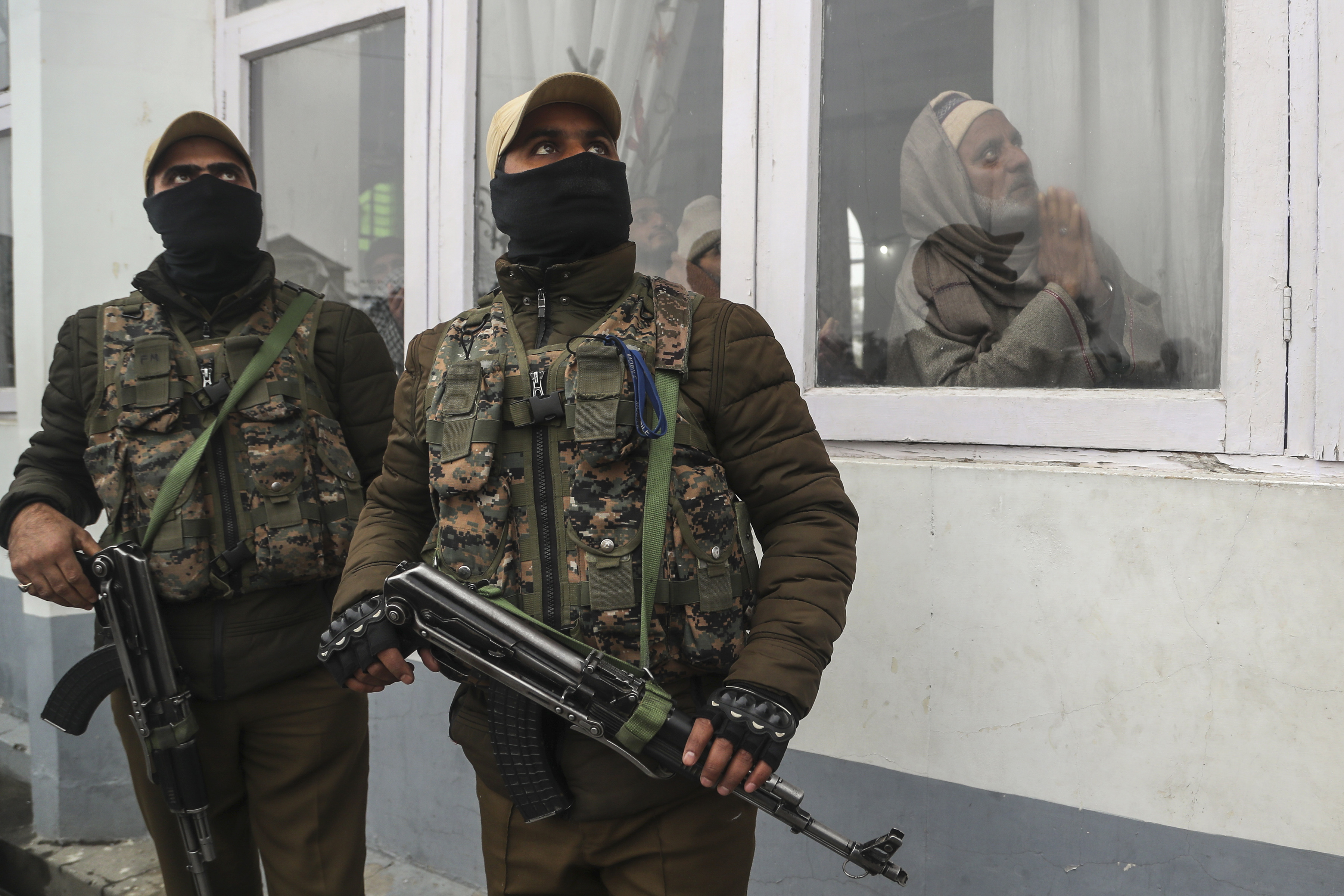 Policías indios vigilan mientras los musulmanes de Cachemira rezan y el sacerdote jefe, invisible, muestra una reliquia del profeta Mahoma del Islam en el santuario de Hazratbal, con motivo del aniversario del nacimiento del profeta en Srinagar, India, el 10 de noviembre de 2019. (AP /Mukhtar Khan)