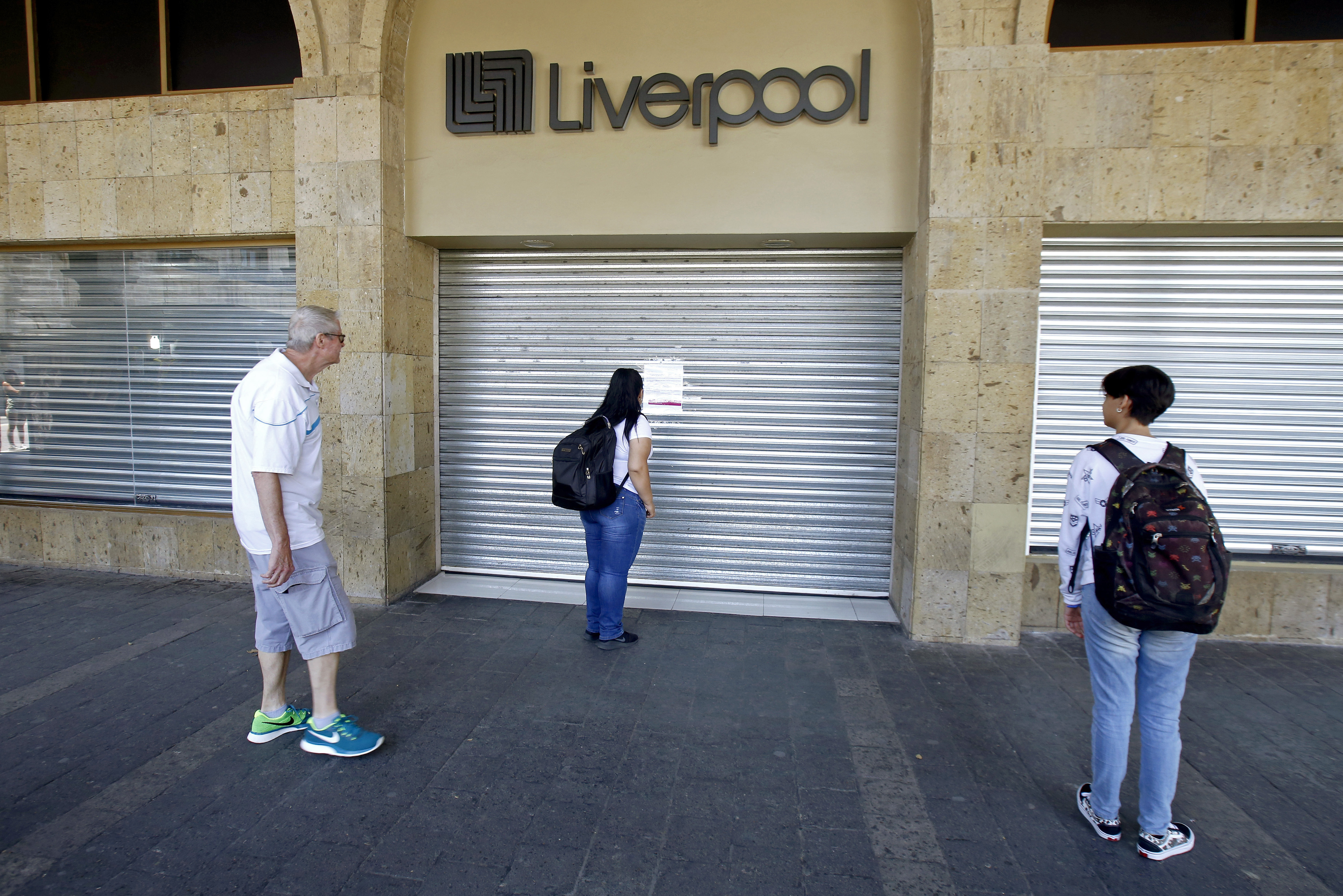 Una mujer mira un aviso dejado en una entrada de los grandes almacenes de Liverpool después de que cerró sus puertas debido a la nueva pandemia de coronavirus COVID-19, en Guadalajara, México, el 31 de marzo de 2020.