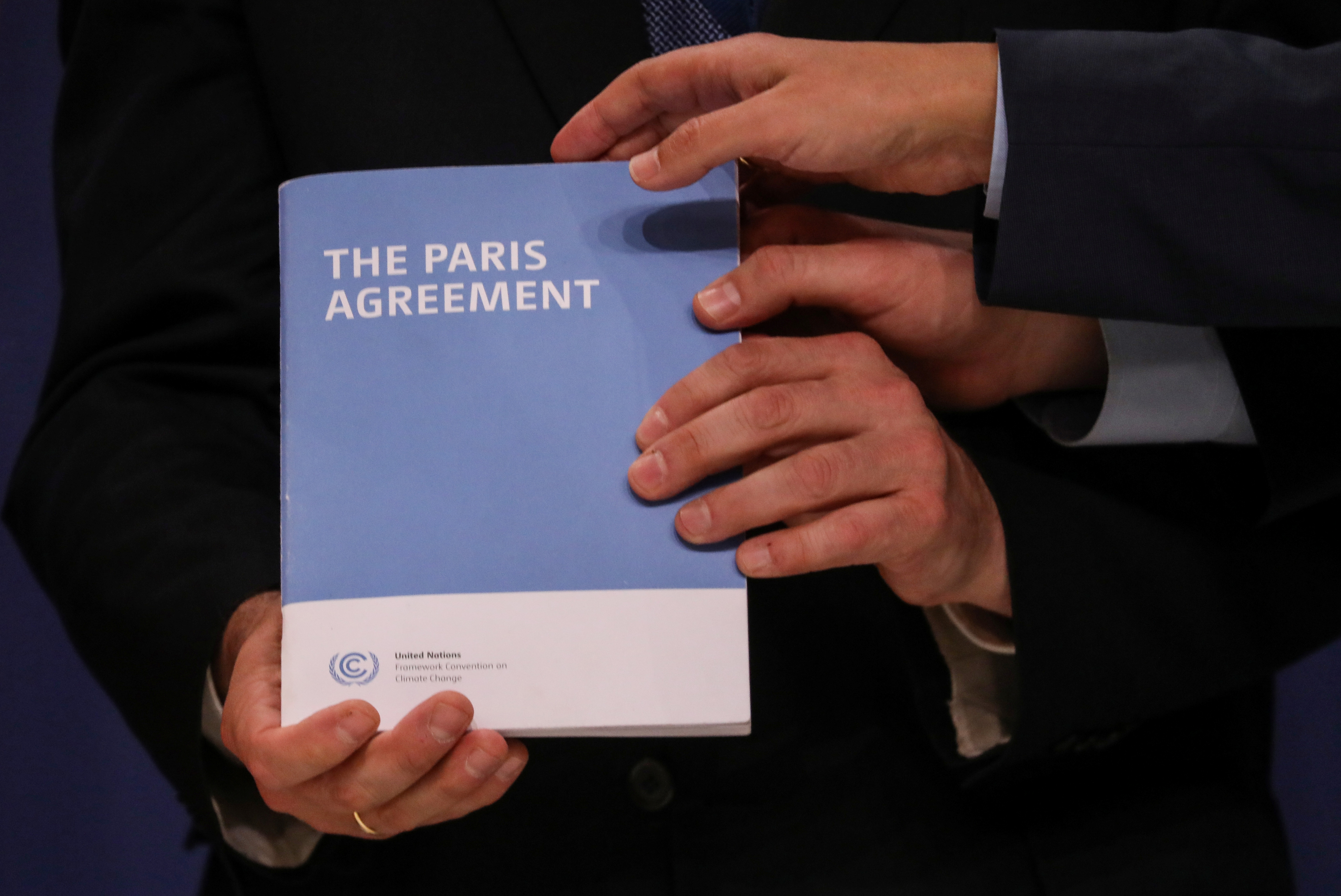 El campeón climático de alto nivel COP25, Gonzalo Muñoz, tiene la copia del Acuerdo de París mientras posa con el ex Ministro de Estado de Energía y Crecimiento Limpio de Gran Bretaña y el nuevo Presidente de la COP26, Claire Perry, el Ministro de Medio Ambiente italiano Sergio Costa y el Secretario de Estado de Medio Ambiente español Hugo Moran (no en la foto) durante la Conferencia de las Naciones Unidas sobre el Cambio Climático (COP25) en Madrid, España, 13 de diciembre de 2019. REUTERS / Susana Vera