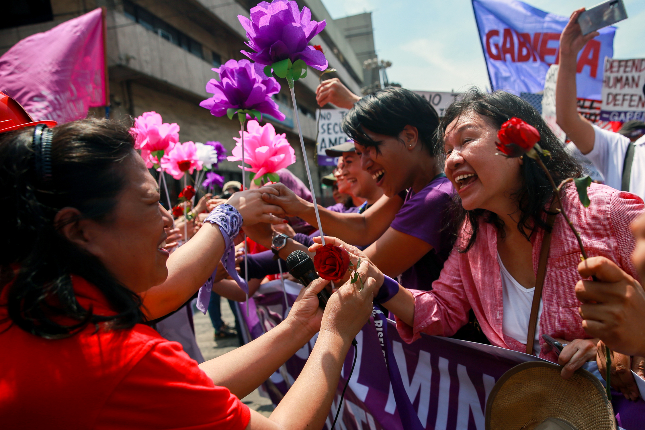 Mujeres intercambian flores durante la marcha en Manila, Filipinas (REUTERS/Eloisa Lopez)