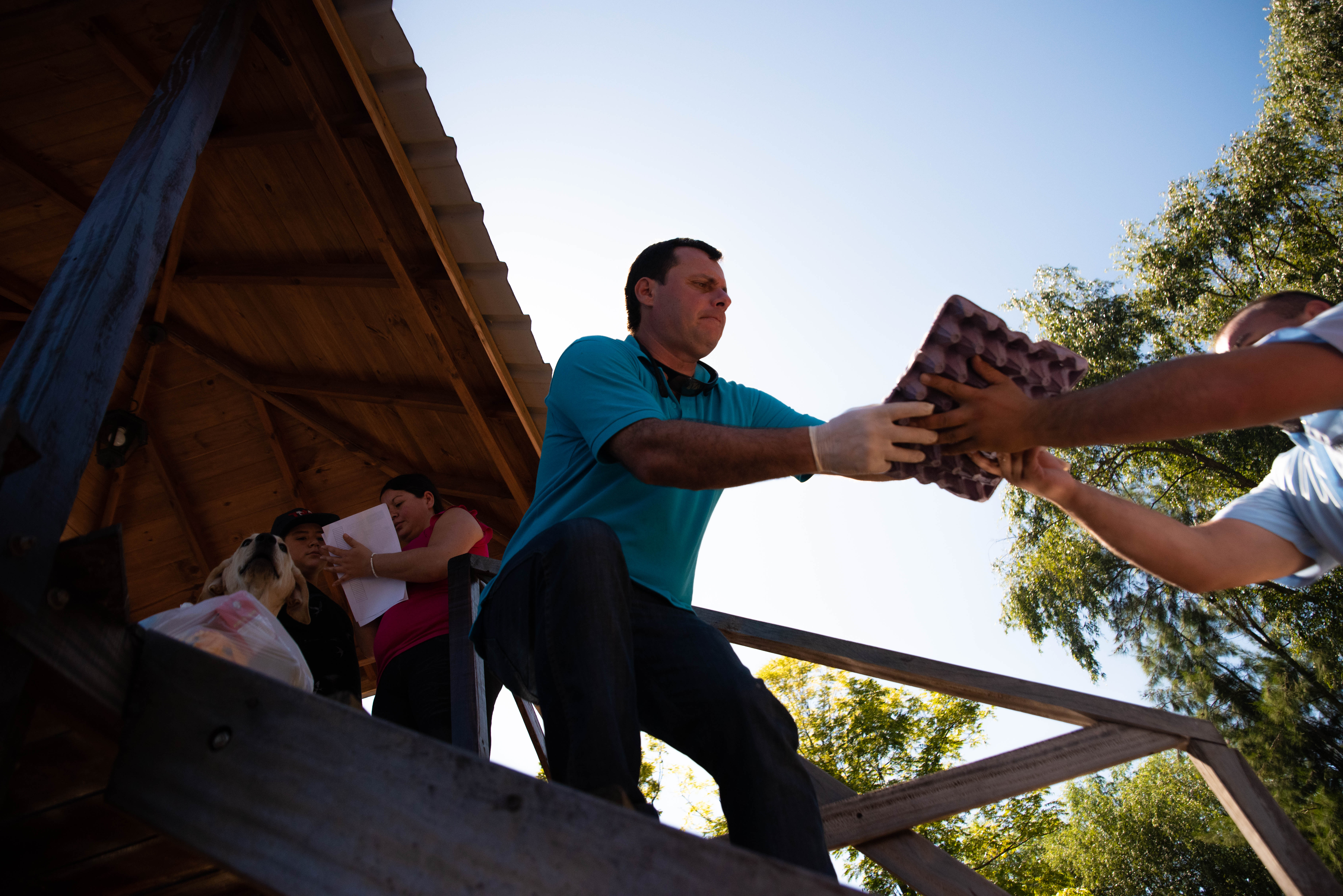 Diego, uno de los docentes que participó de la entrega de kits, descarga alimentos frente a la casa de uno de sus alumnos. (Foto: Franco Fafasuli)