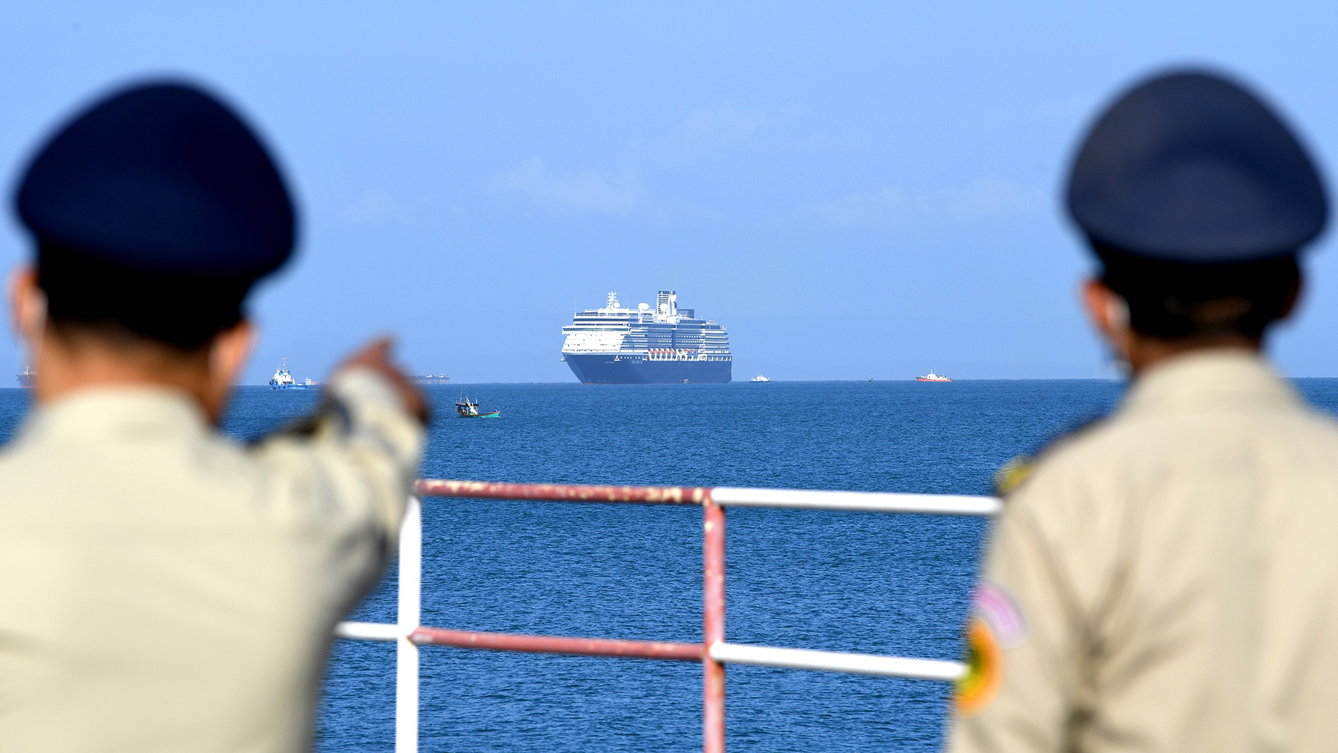 El crucero de Westerdam es visto por policías camboyanos cuando se acerca al puerto de Sihanoukville, la costa sur de Camboya, el 13 de febrero de 2020, donde el barco recibió permiso para atracar después de que se le negó la entrada a otros puertos asiáticos debido a los temores del coronavirus (TANG CHHIN Sothy / AFP)