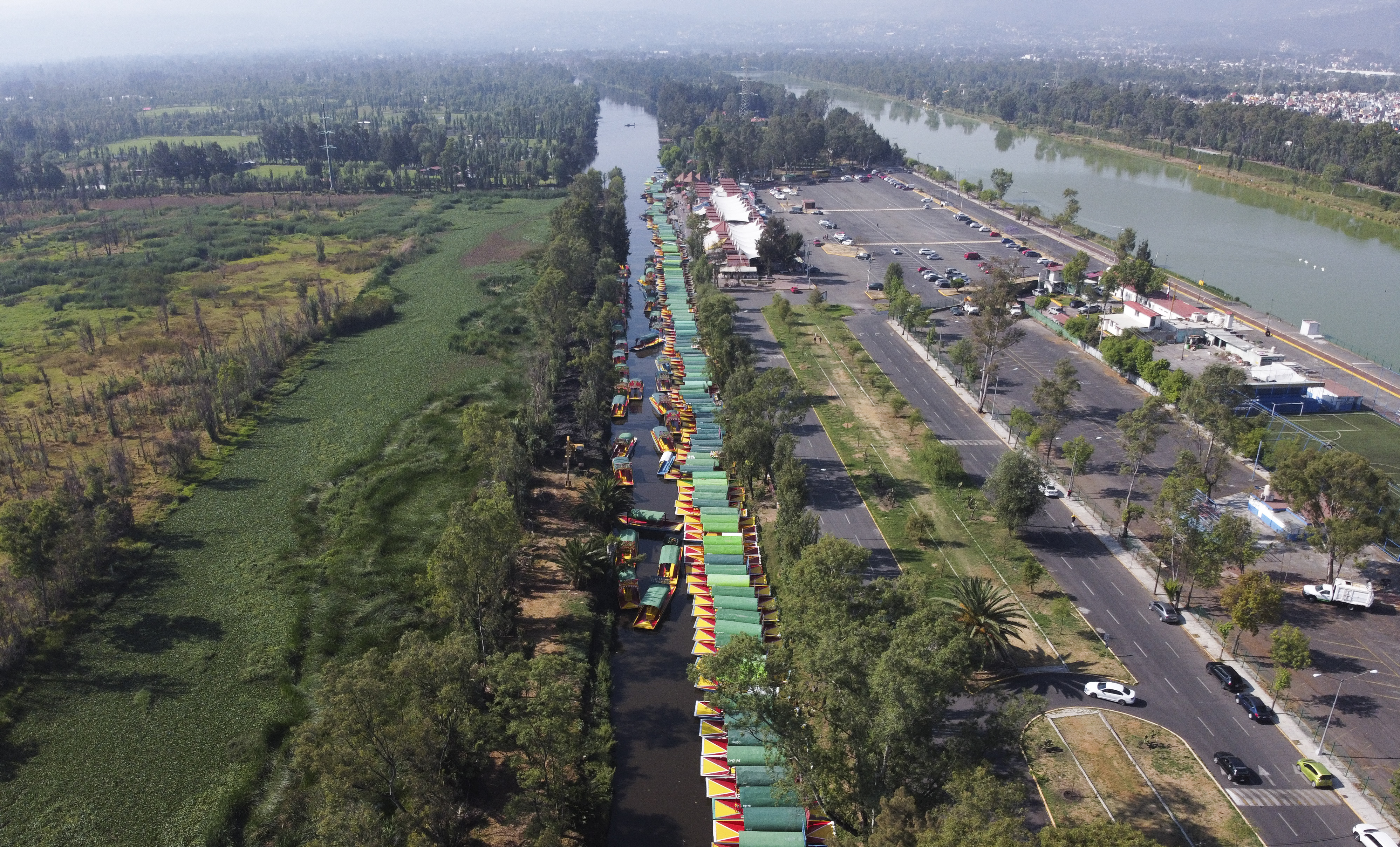 Una línea de trajineras, los botes de madera pintados populares entre los turistas que navegan por los canales en el distrito de Xochimilco de la Ciudad de México, esperan a los visitantes el domingo 22 de marzo de 2020.