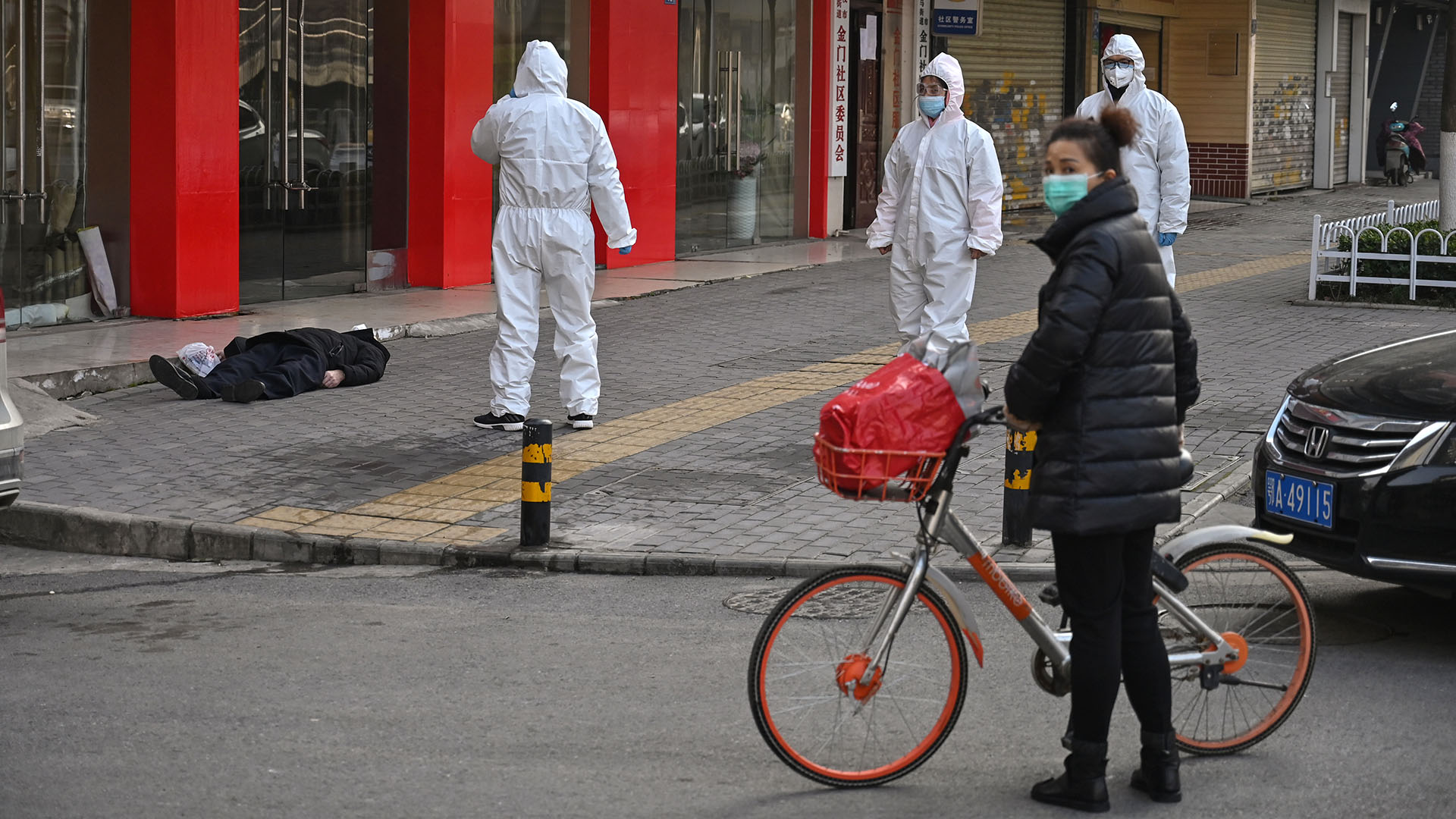 Un anciano con una máscara facial murió en una calle cercana a un hospital en Wuhan (Héctor RETAMAL / AFP) 