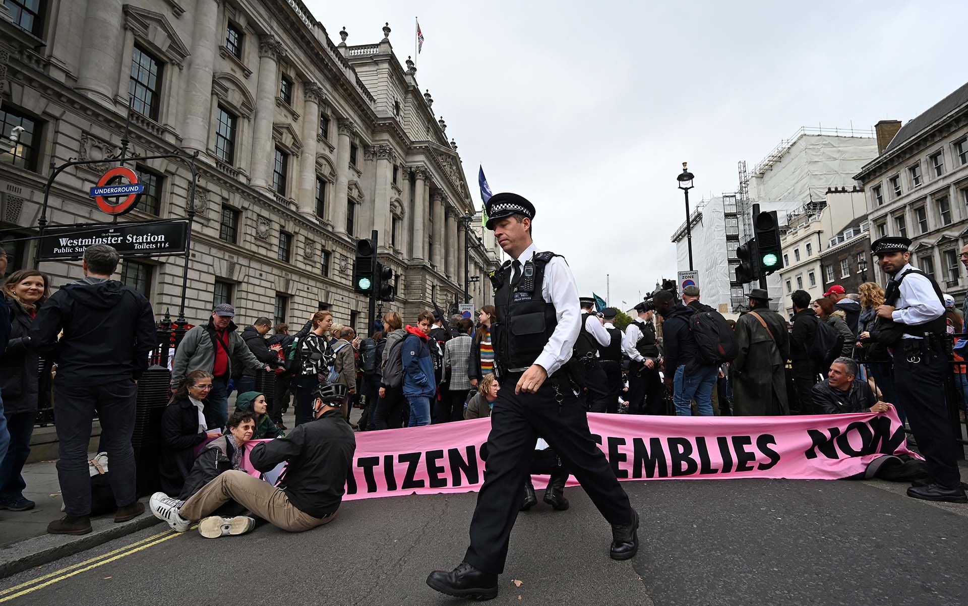 Oficiales de policía británicos hablan con activistas del cambio climático del grupo Extinction Rebellion, como lo demuestran mientras bloquean el cruce de las calles Whitehall y Parliament Square en el centro de Londres, el 7 de octubre de 2019. (Foto de Ben STANSALL / AFP)