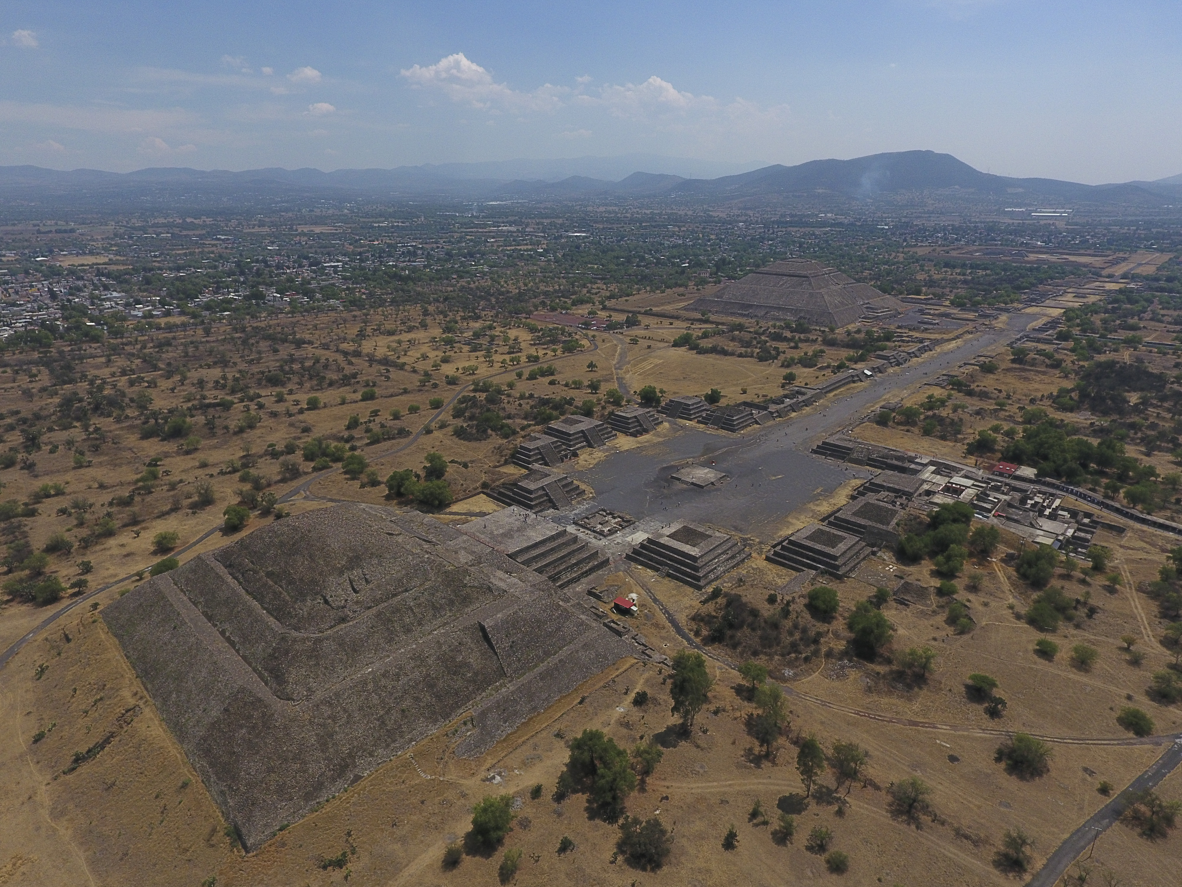 La Pirámide de la Luna, izquierda, y la Pirámide del Sol, atrás a la derecha, se ven junto con estructuras más pequeñas que bordean la Calzada de los Muertos, en Teotihuacan, México, el jueves 19 de marzo de 2020.