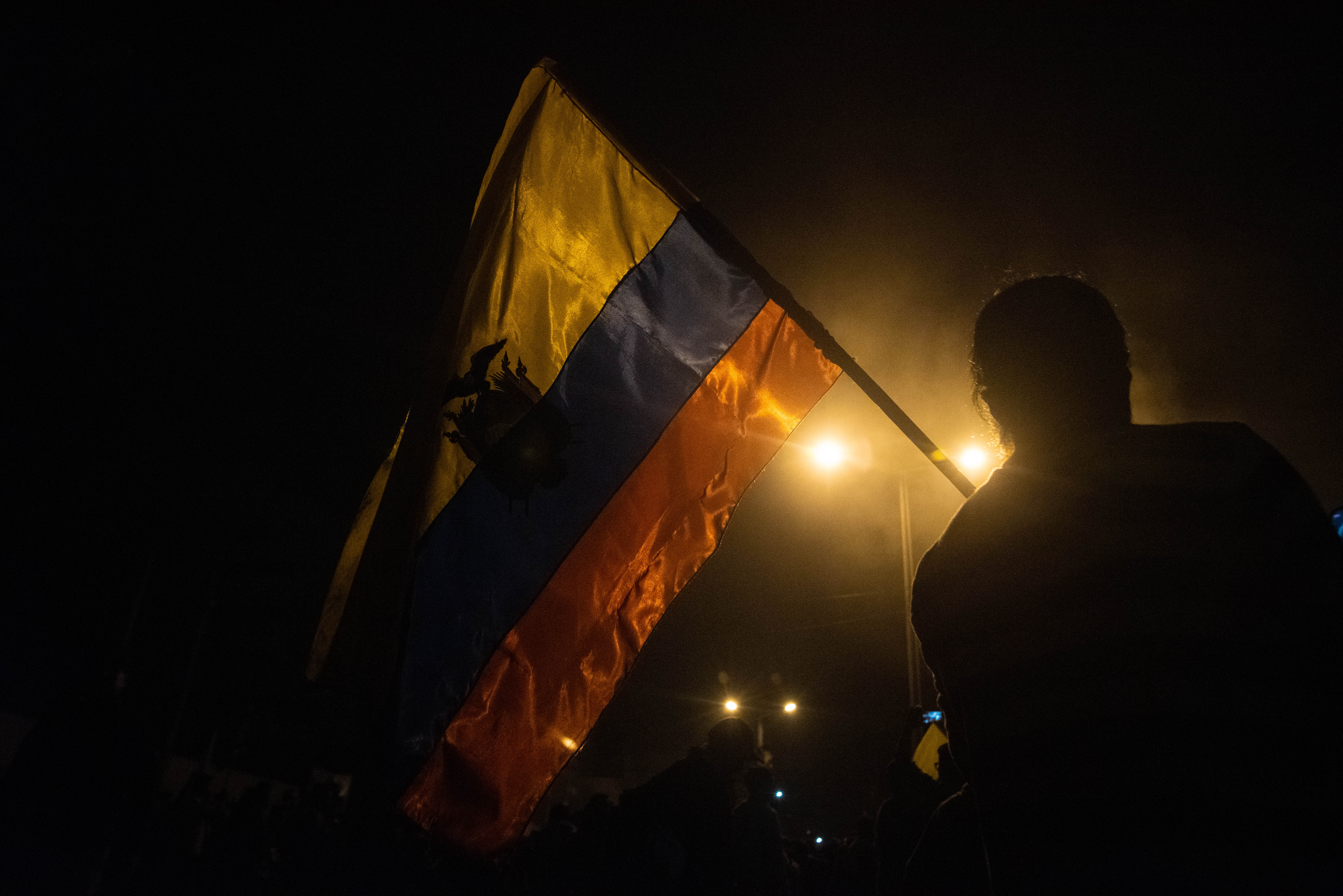 Un ciudadano festeja con la bandera ecuatoriana en alto durante las celebraciones que estallaron el domingo por la noche en la capital ecuatoriana.