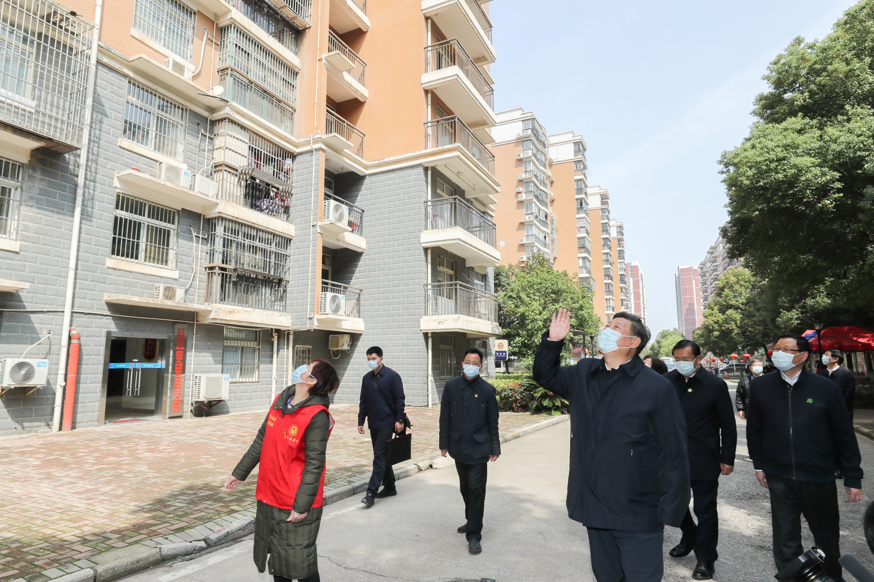 El presidente chino, Xi Jinping, saluda a los residentes que están en cuarentena en sus casas en una comunidad en Wuhan, el epicentro del nuevo brote de coronavirus, provincia de Hubei, China, este 10 de marzo. Fue su régimen el que censuró a los médicos que alertaban sobre el virus (Reuters)