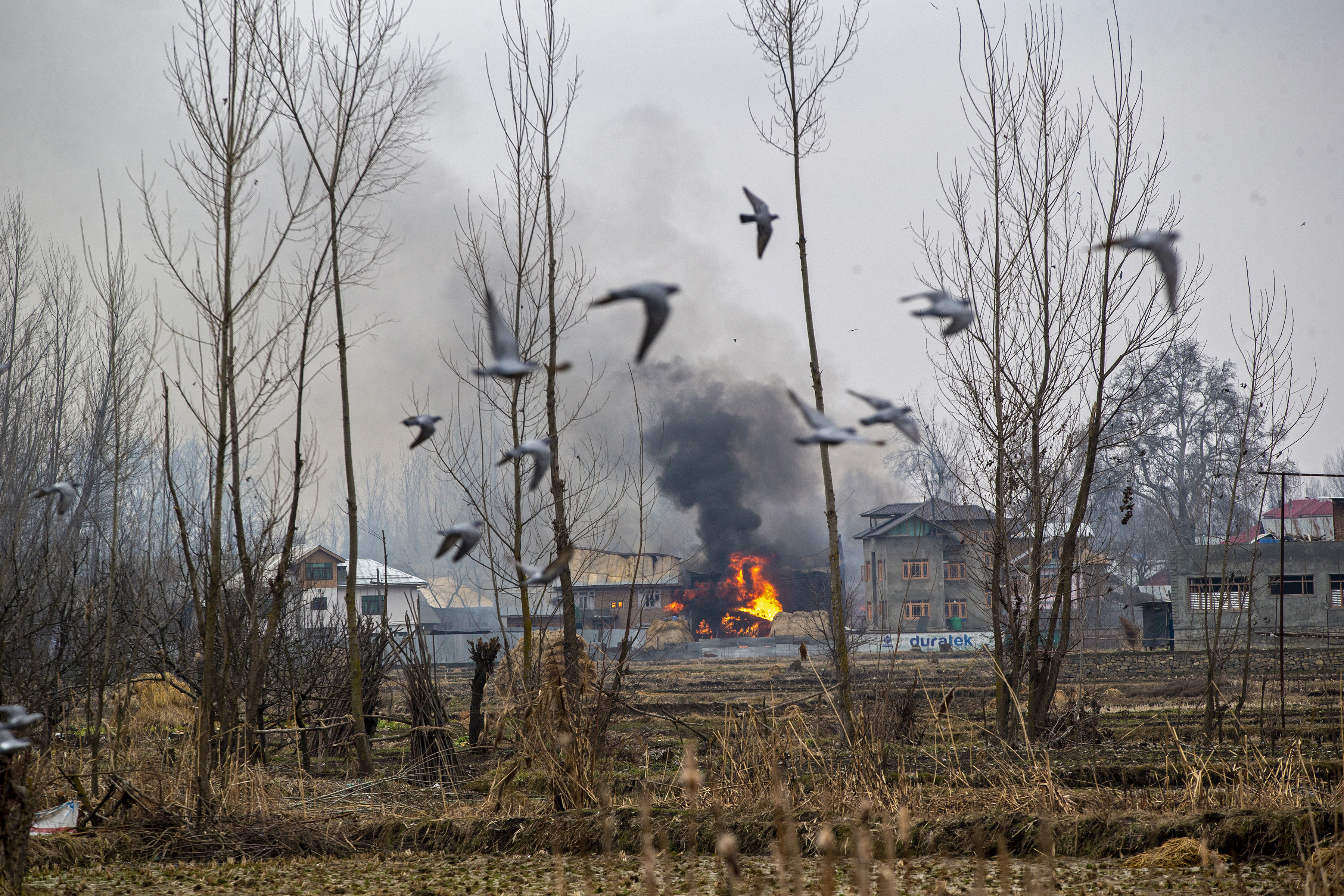 Las llamas y el humo se elevan desde un edificio residencial donde se sospecha que militantes se refugiaron durante un tiroteo en Pulwama, al sur de Srinagar (Foto AP / Dar Yasin)